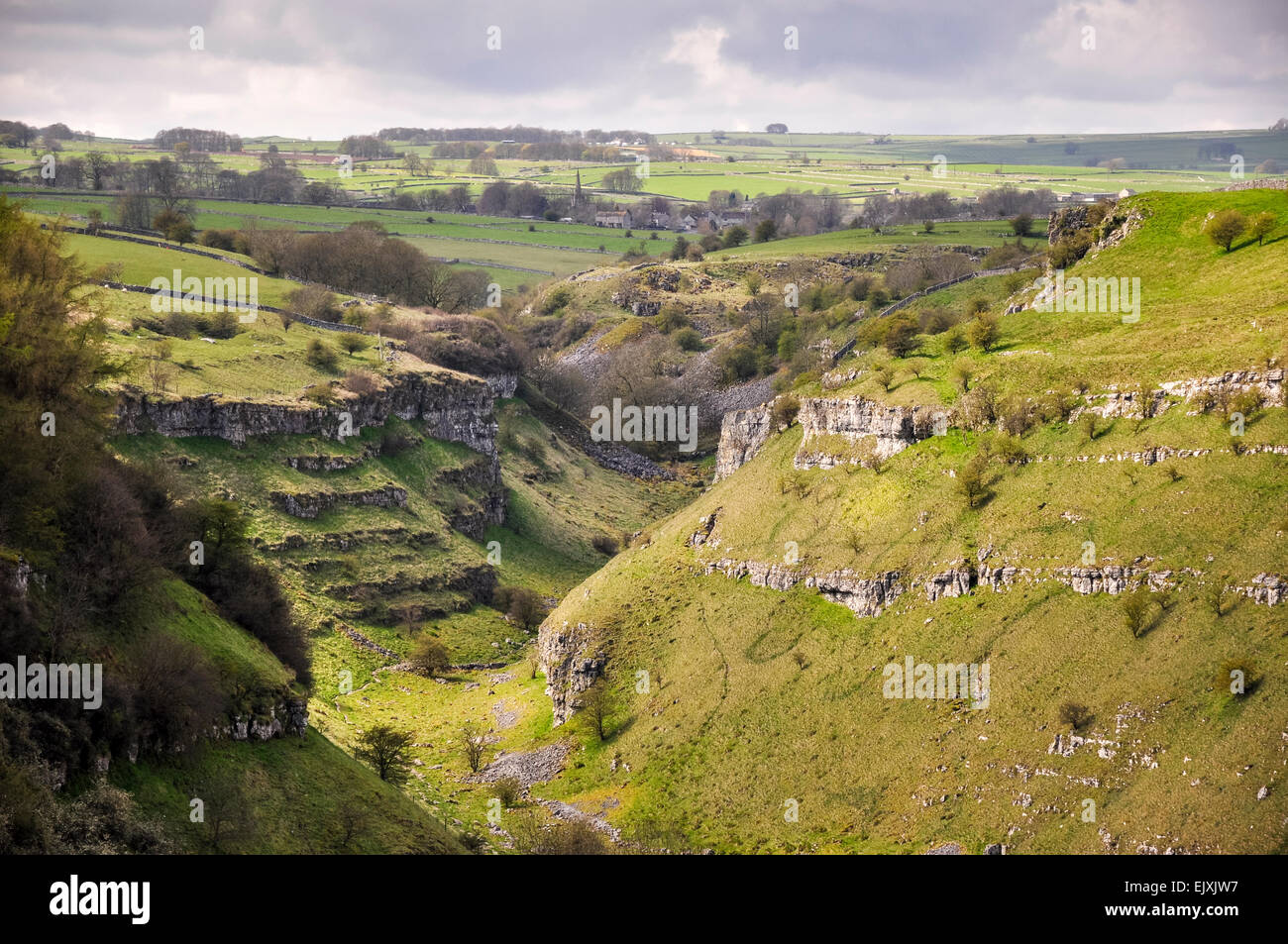 The upper section of Lathkill Dale with view toward the village of Monyash. A sunny spring day in the Peak District. Stock Photo