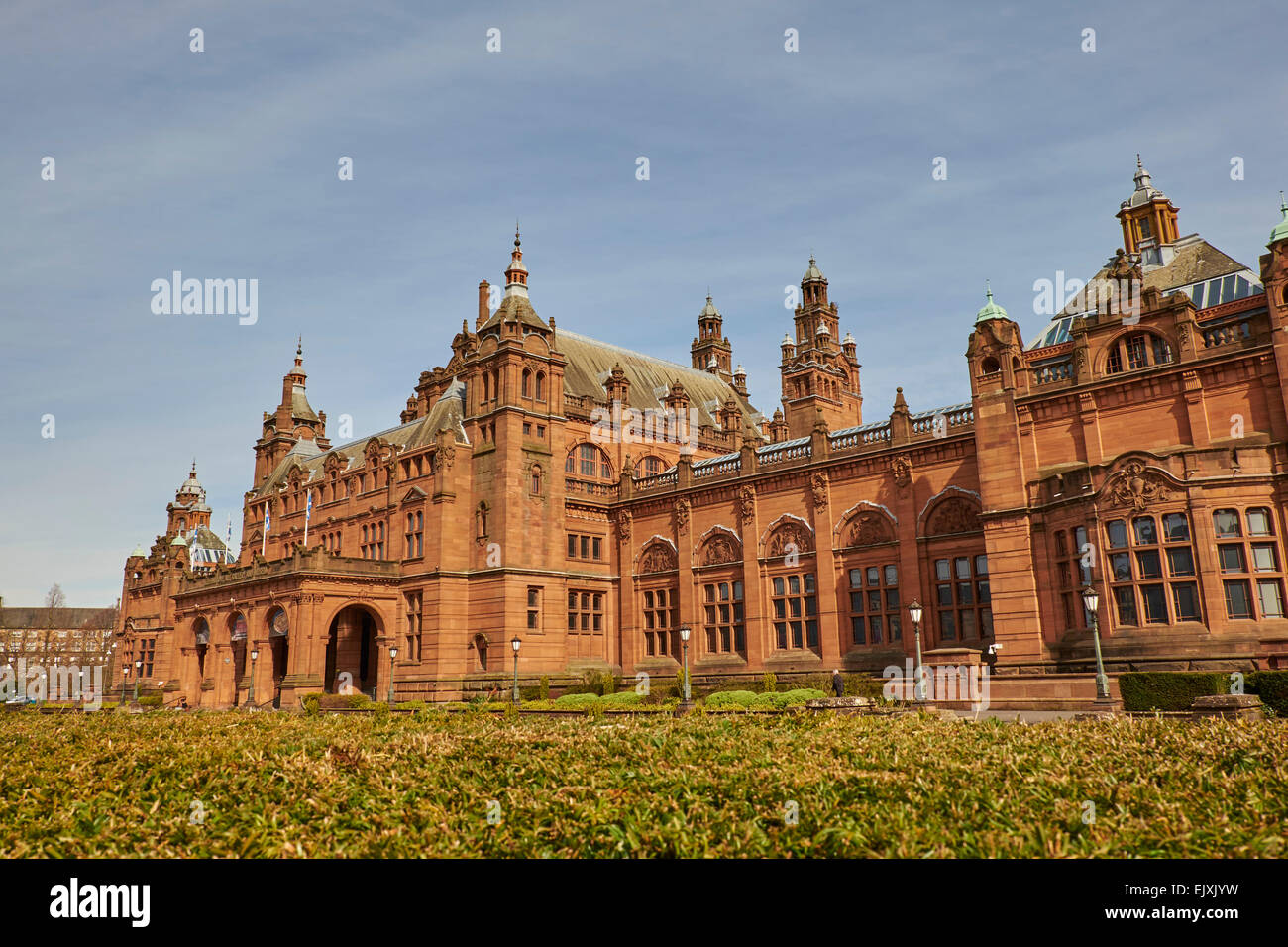 Long view of the Kelvingrove Art Gallery & Museum with foreground hedgerow and blue sky, Glasgow, Scotland, UK Stock Photo