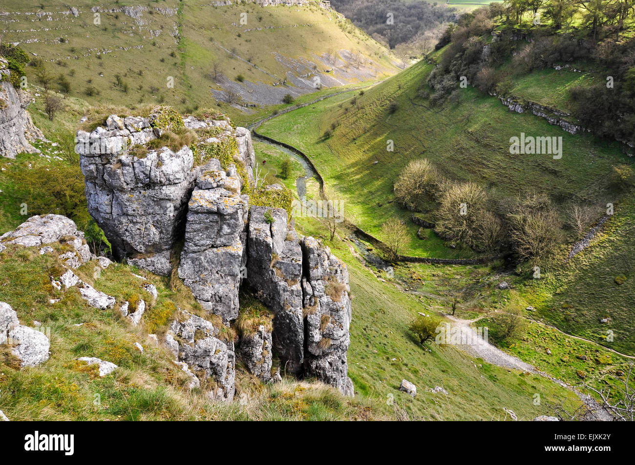 Parsons Tor in Lathkill Dale on a sunny spring day. Look down into the Dale with limestone crags in the foreground. Stock Photo
