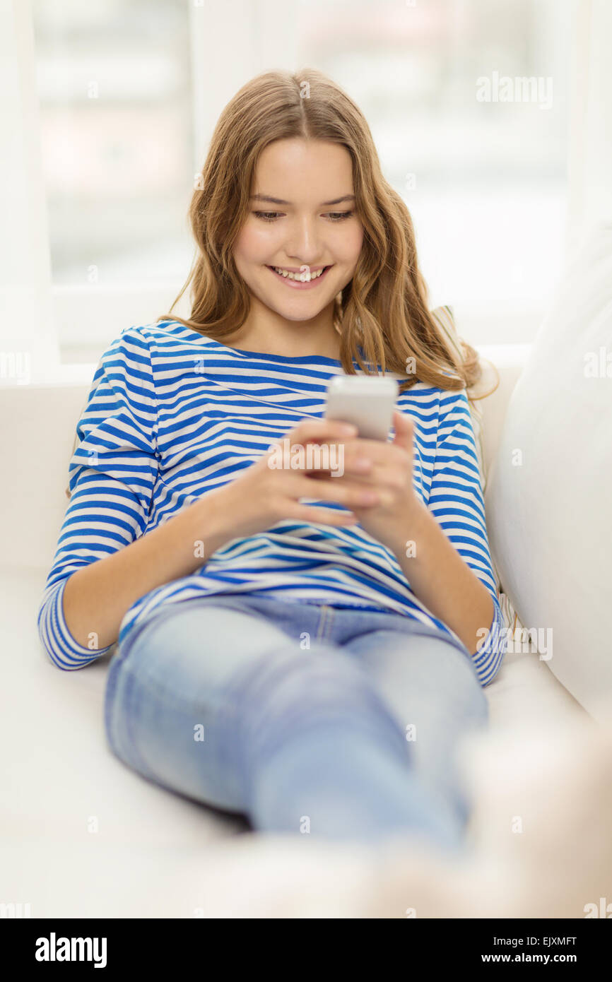 smiling teenage girl with smartphone at home Stock Photo - Alamy
