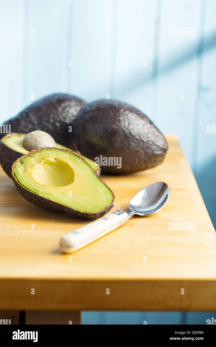 the halved avocado on kitchen table Stock Photo