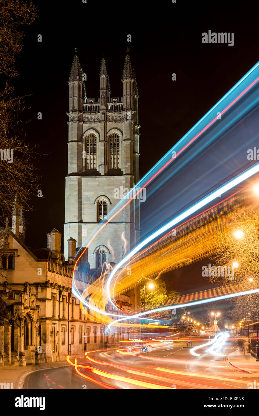 Views down the High Street to the tower of Magdalen College, Oxford University as the light trail from cars streak by; Oxford UK Stock Photo