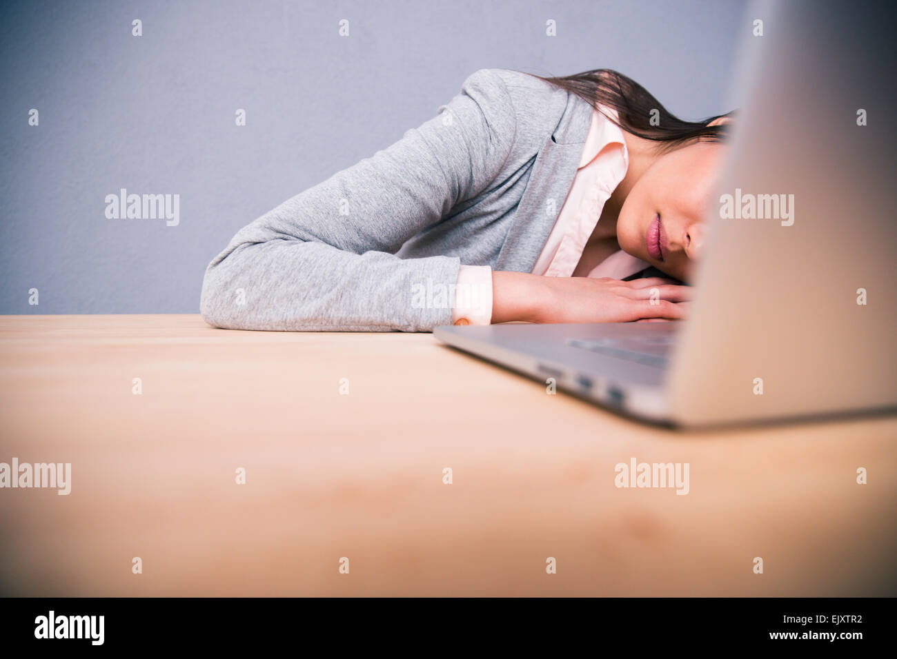 Cute business woman sleeping on the table with laptop Stock Photo