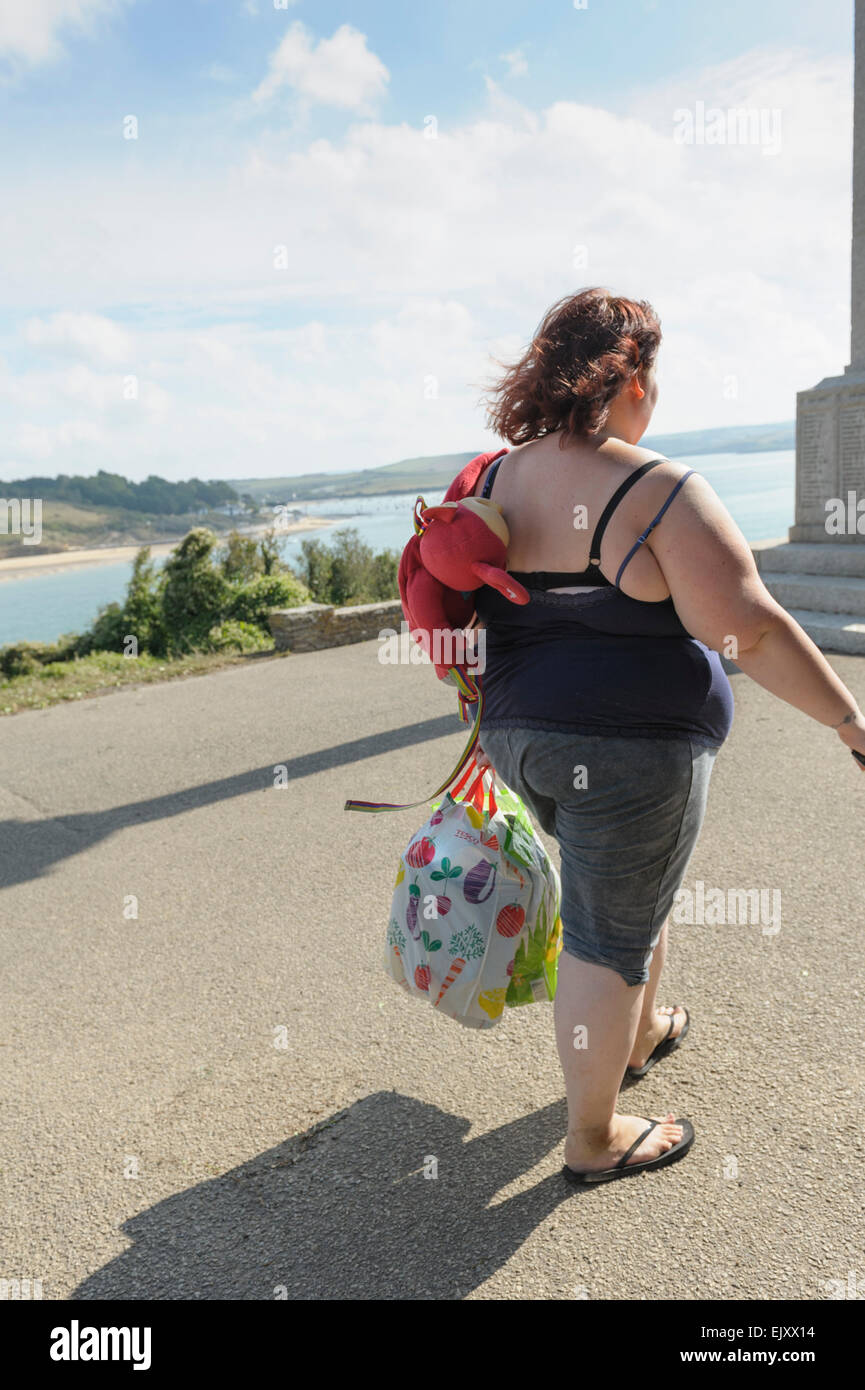 Young overweight woman enjoying summer sunshine by the sea. Stock Photo