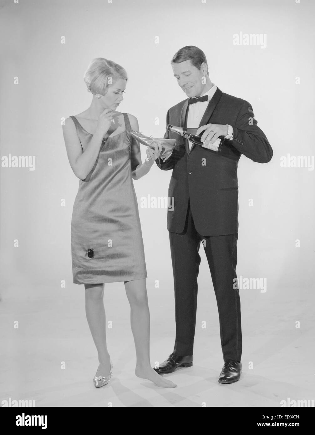 Reveille Studio Champagne from a slipper. Models pat Hinwood and Ray Curtis. Circa 1960 Stock Photo