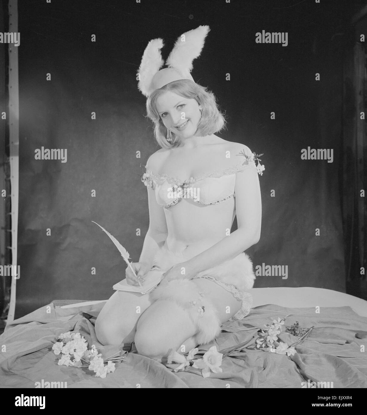 Reveille Easter Bunny Feature. Model Peggy Cage nseen here wearing a fur trim bathing costume and rabbit ears Circa 1960 Stock Photo