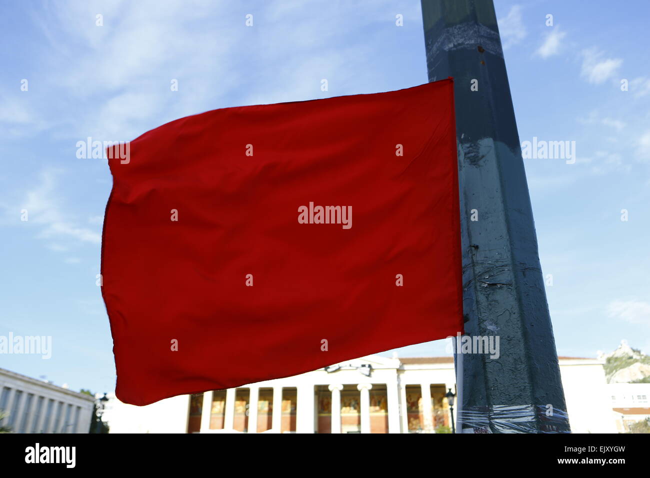 Athens, Greece. 2nd April 2015. A red flag flies outside the Propylaea of the University of Athens. A handful of protesters showed their solidarity with the two killed activists who had taken a prosecutor hostage in a Istanbul court house. They were calling for the truth in the killing of 15 year old Berkin Elvan who died during the Gezi protests after being hit by a tear gas canister from the police. Credit:  Michael Debets/Alamy Live News Stock Photo