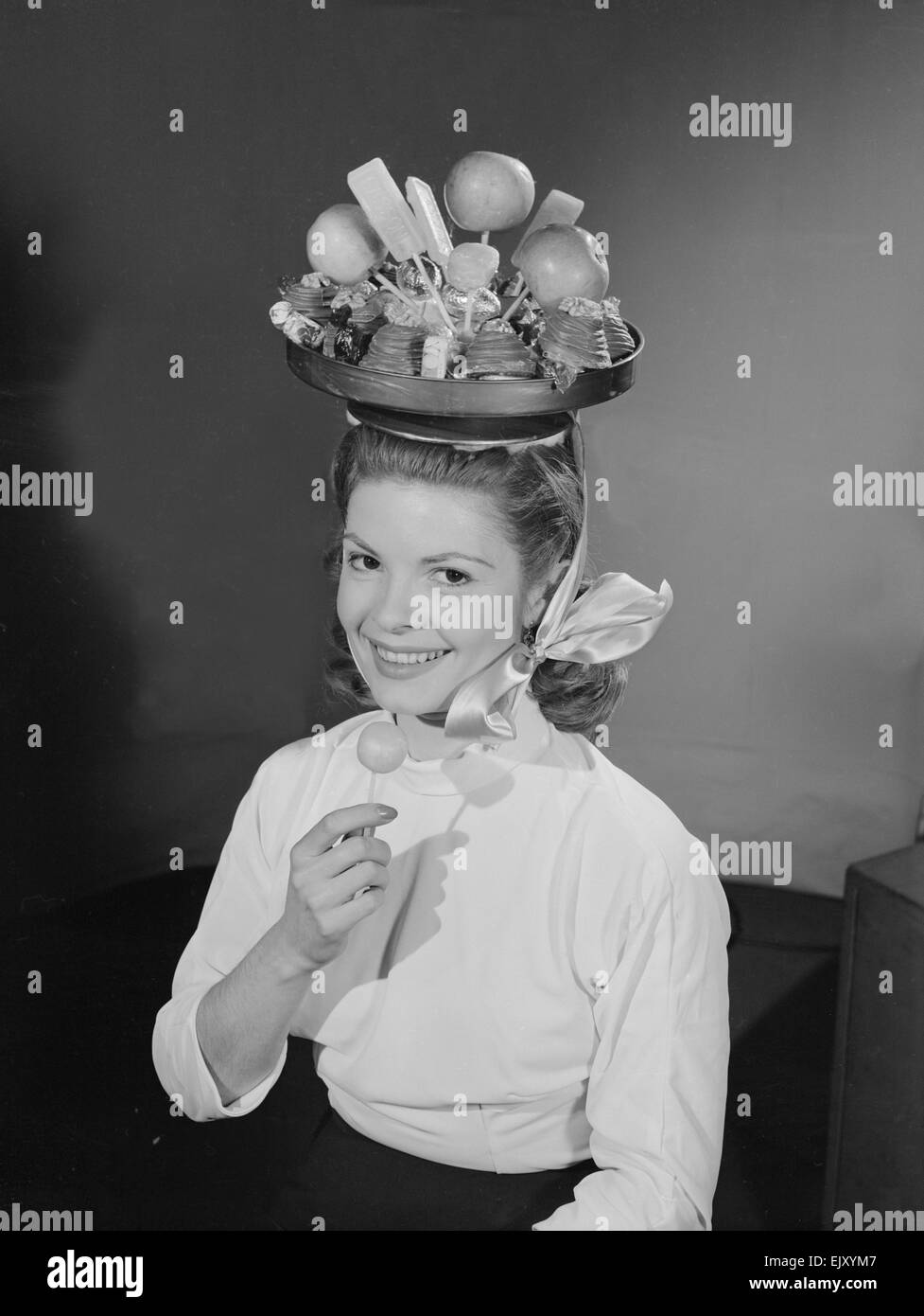Model wearing a hat made from chocolate and fruit. Circa 1960 Stock Photo