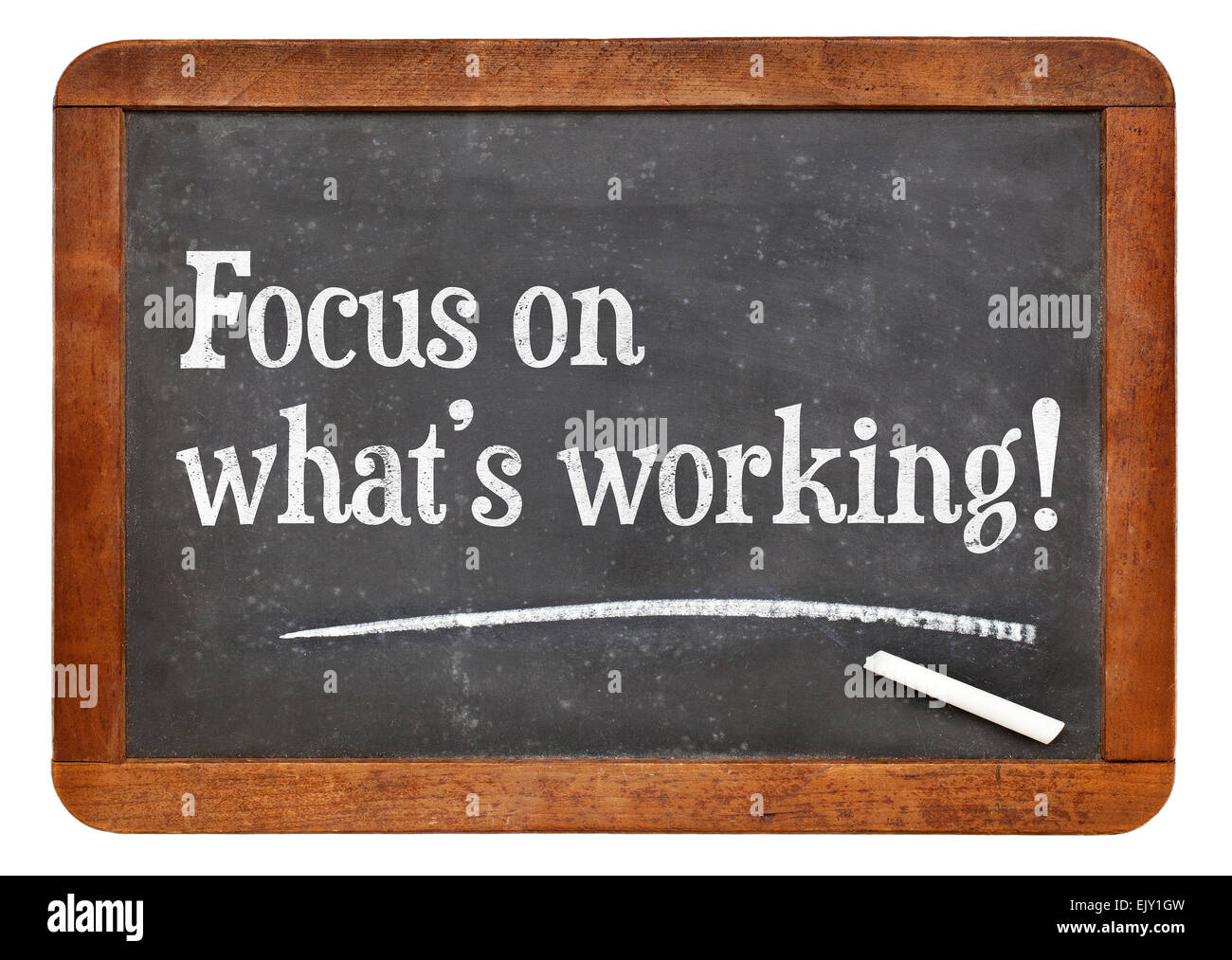 Focus on what is working. Motivational words on a vintage slate blackboard. Stock Photo