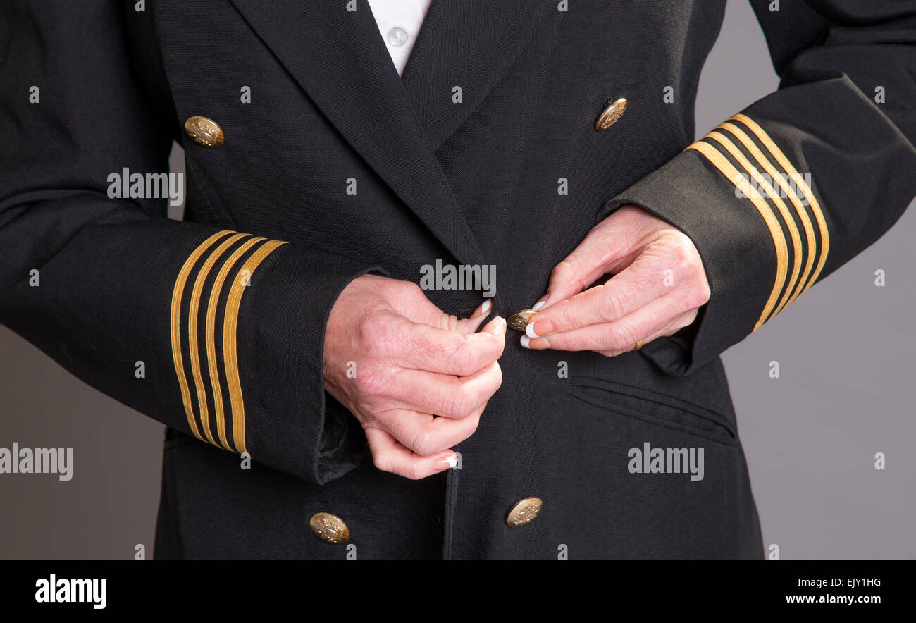 Airline officer fastening button on her uniform Stock Photo