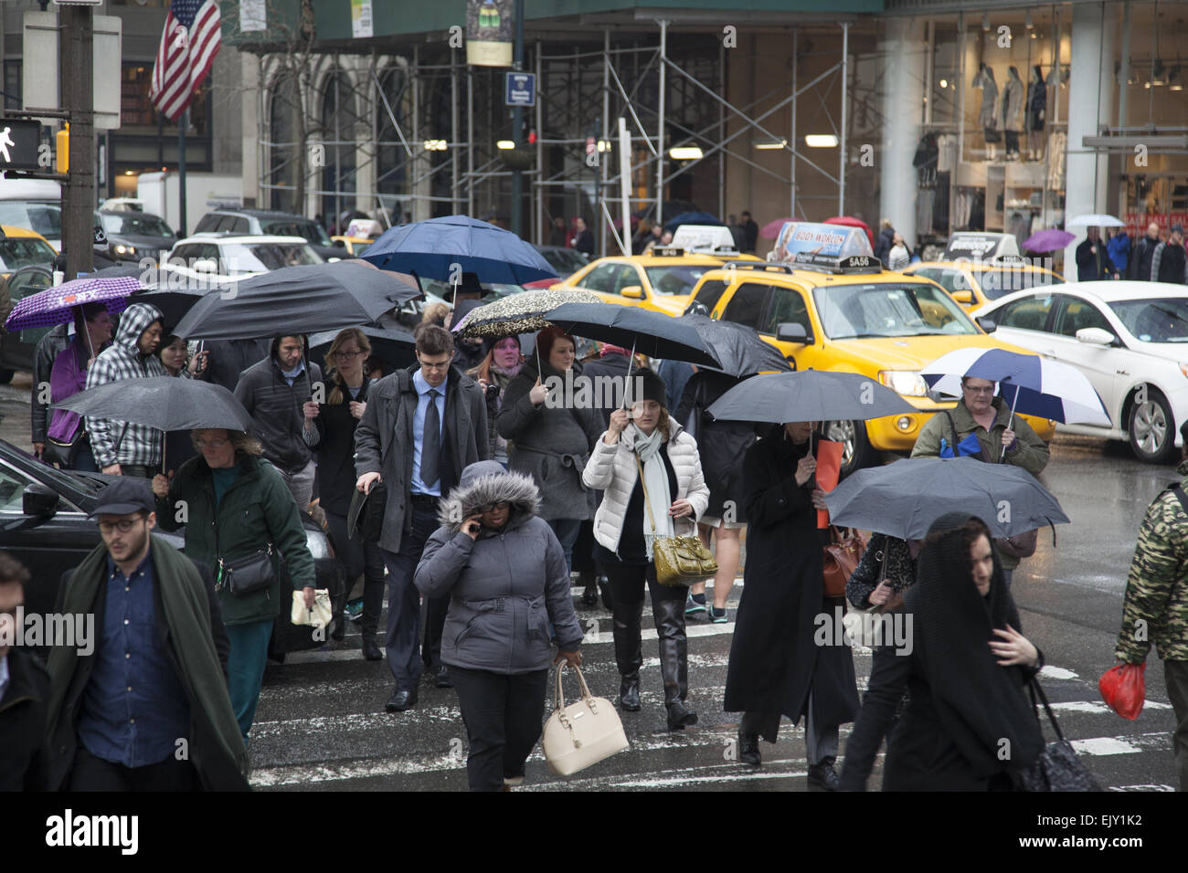 The street remains busy with umbrellas up on a rainy day in midtown Manhattan. Stock Photo