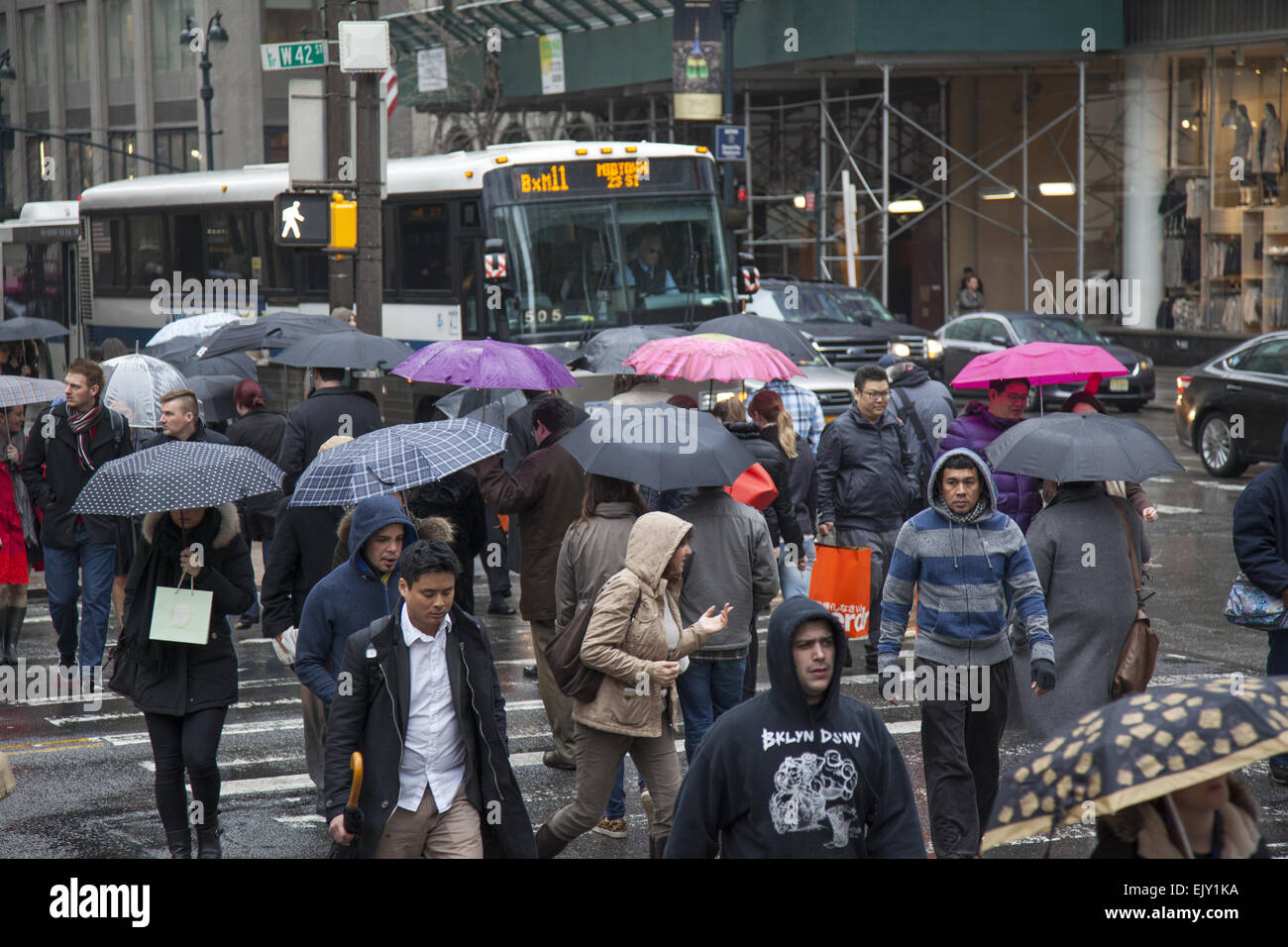 The street remains busy with umbrellas up on a rainy day in midtown Manhattan. Stock Photo