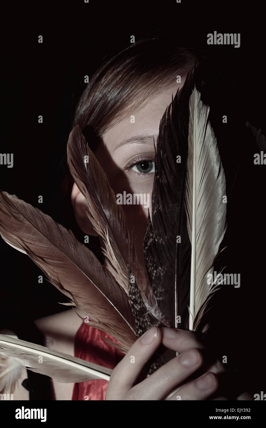 Portrait of a young woman with feathers in hand Stock Photo
