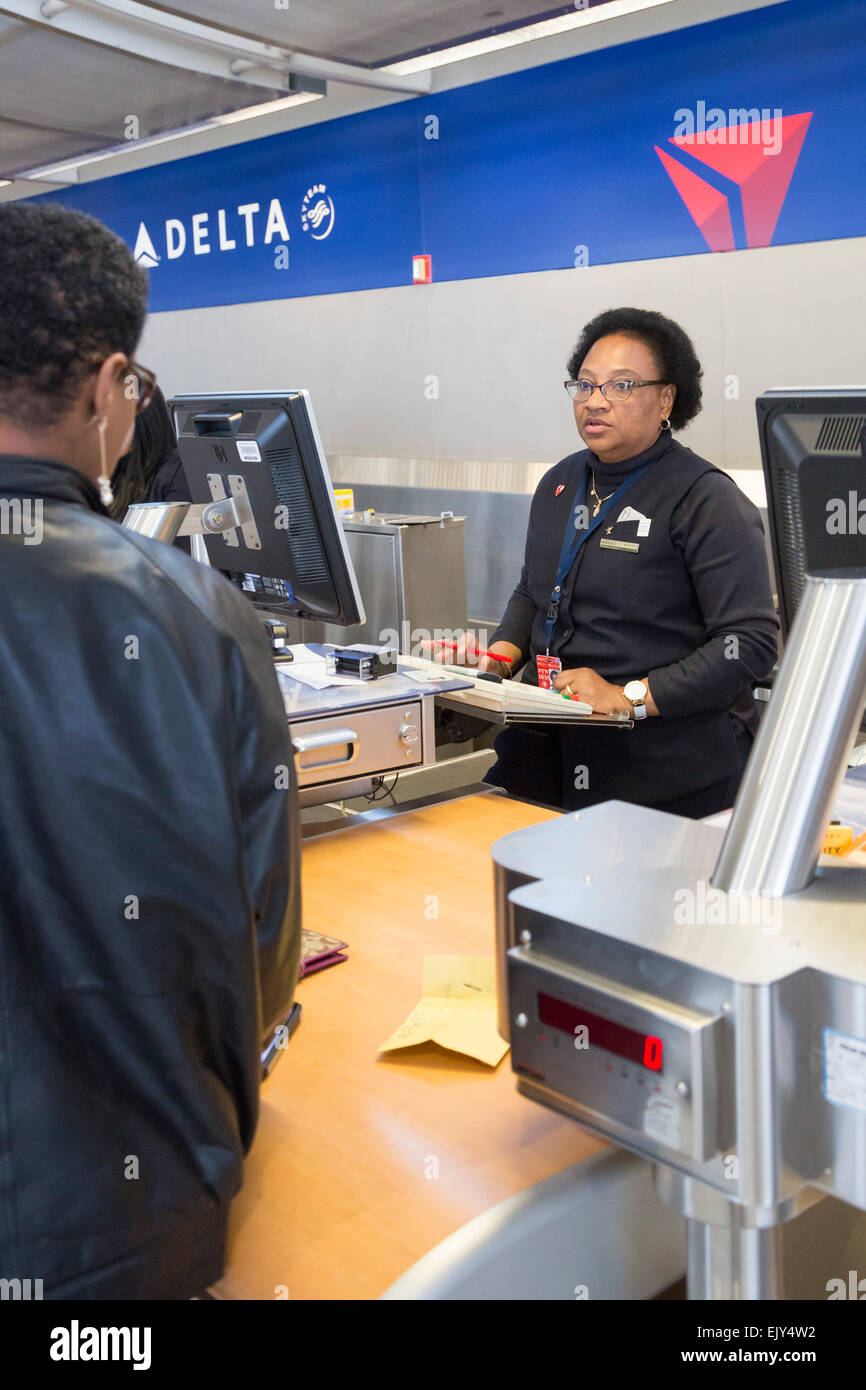 Romulus, Michigan - A Delta Air Lines ticket agent checks in a passenger at Detroit Metro Airport Stock Photo