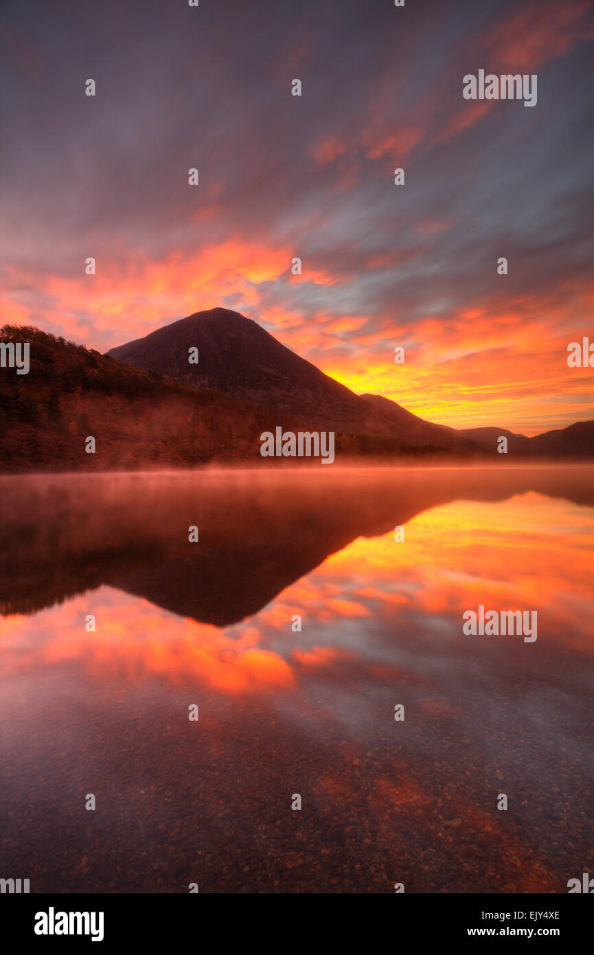 A spectacular sunrise captured from the northern end of Crummock Water in the Lake District National Park. Stock Photo