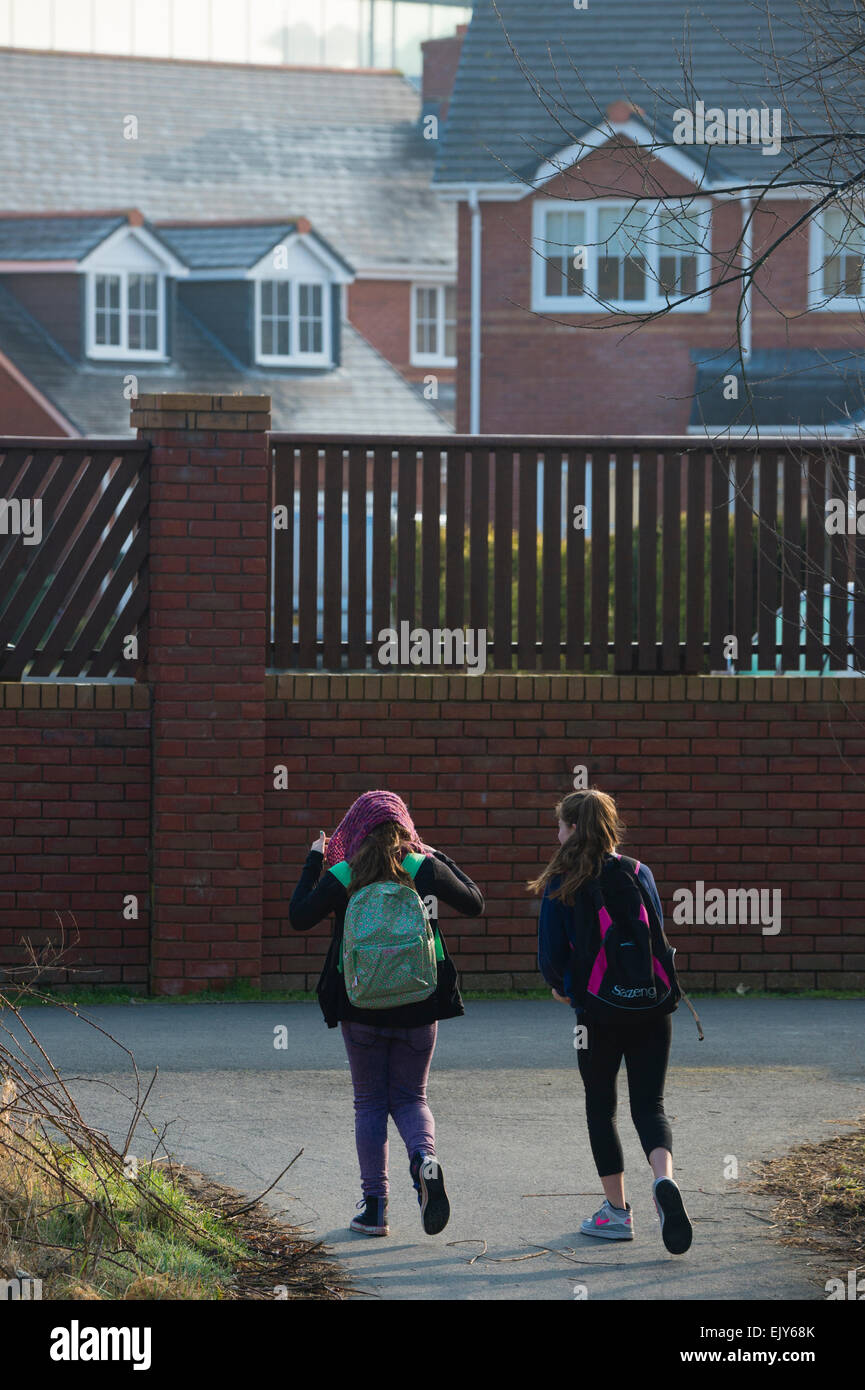 Two Primary-school age children walking to school on a cold winter morning, Wales UK Stock Photo