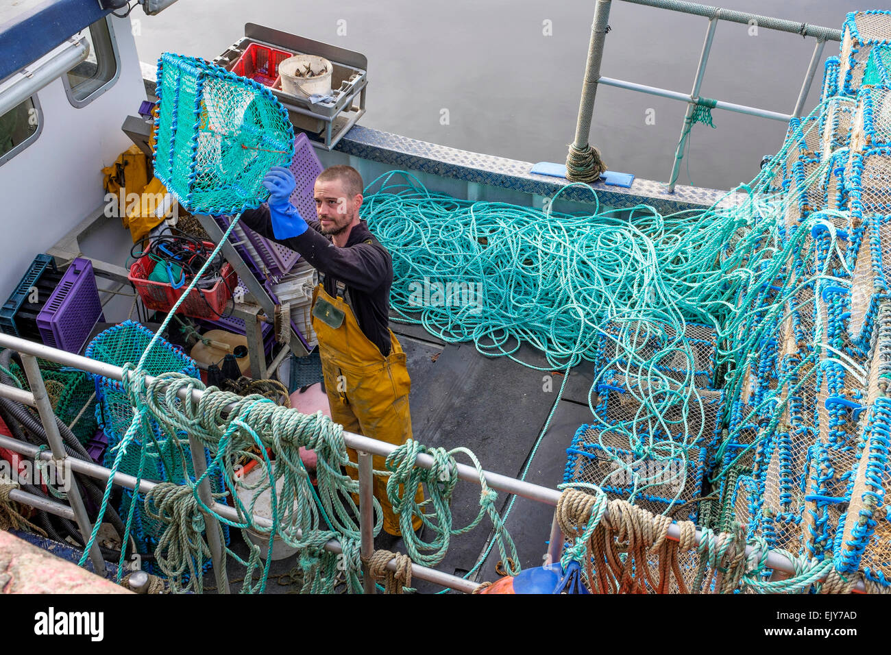Neil McCulloch, prawn fisherman, loading his fishing boat with nets