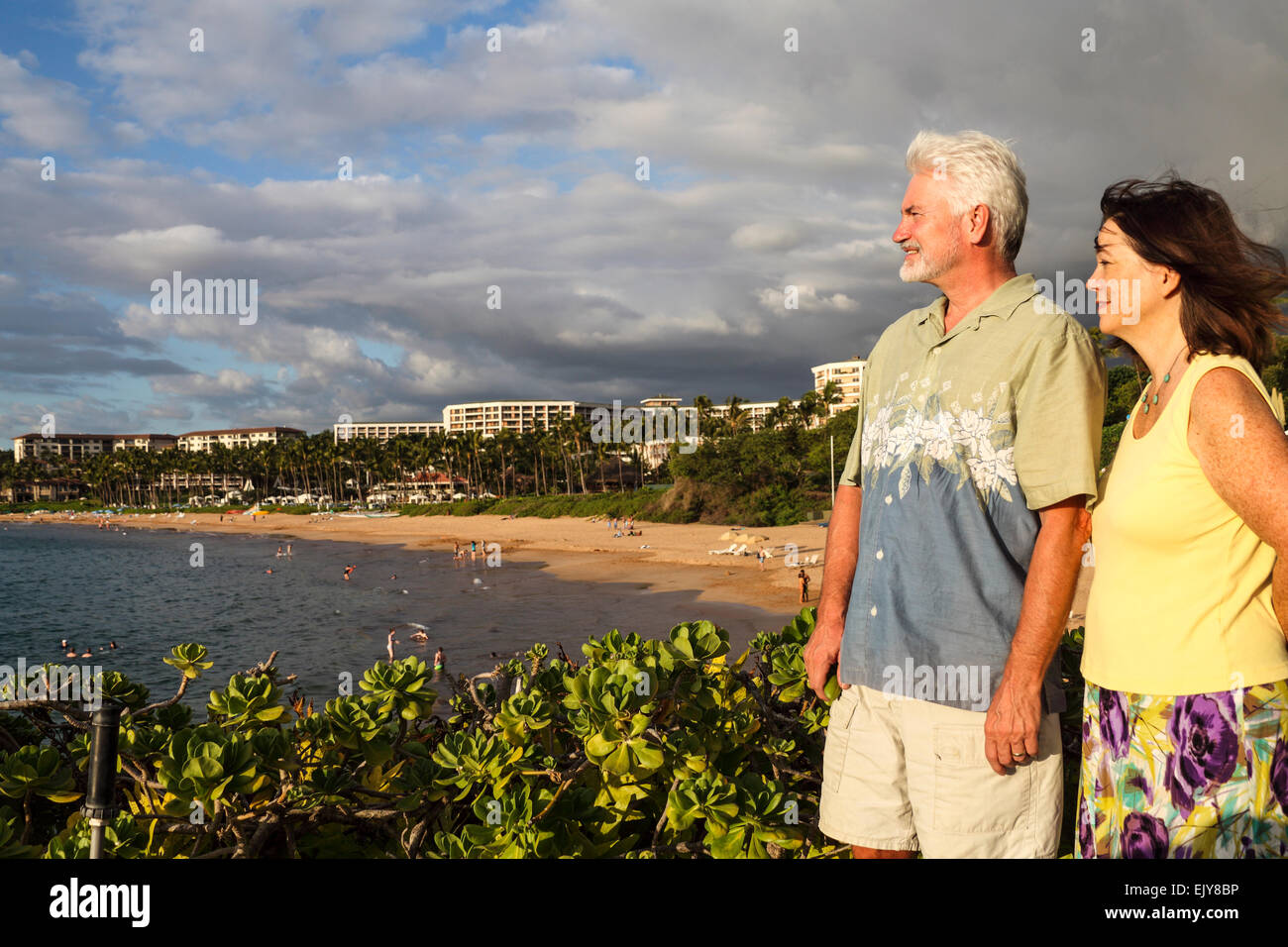 Couple enjoys view from beach walk in Wailea, Maui, at sunset, with Wailea Beach in background Stock Photo