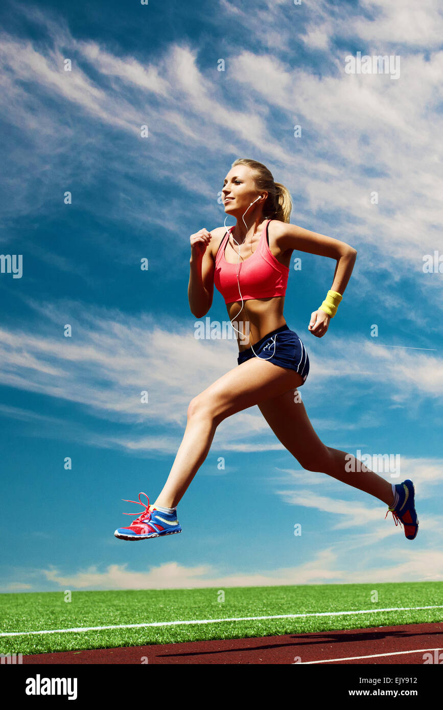 Sport running girl on the background of stadium and sky Stock Photo - Alamy
