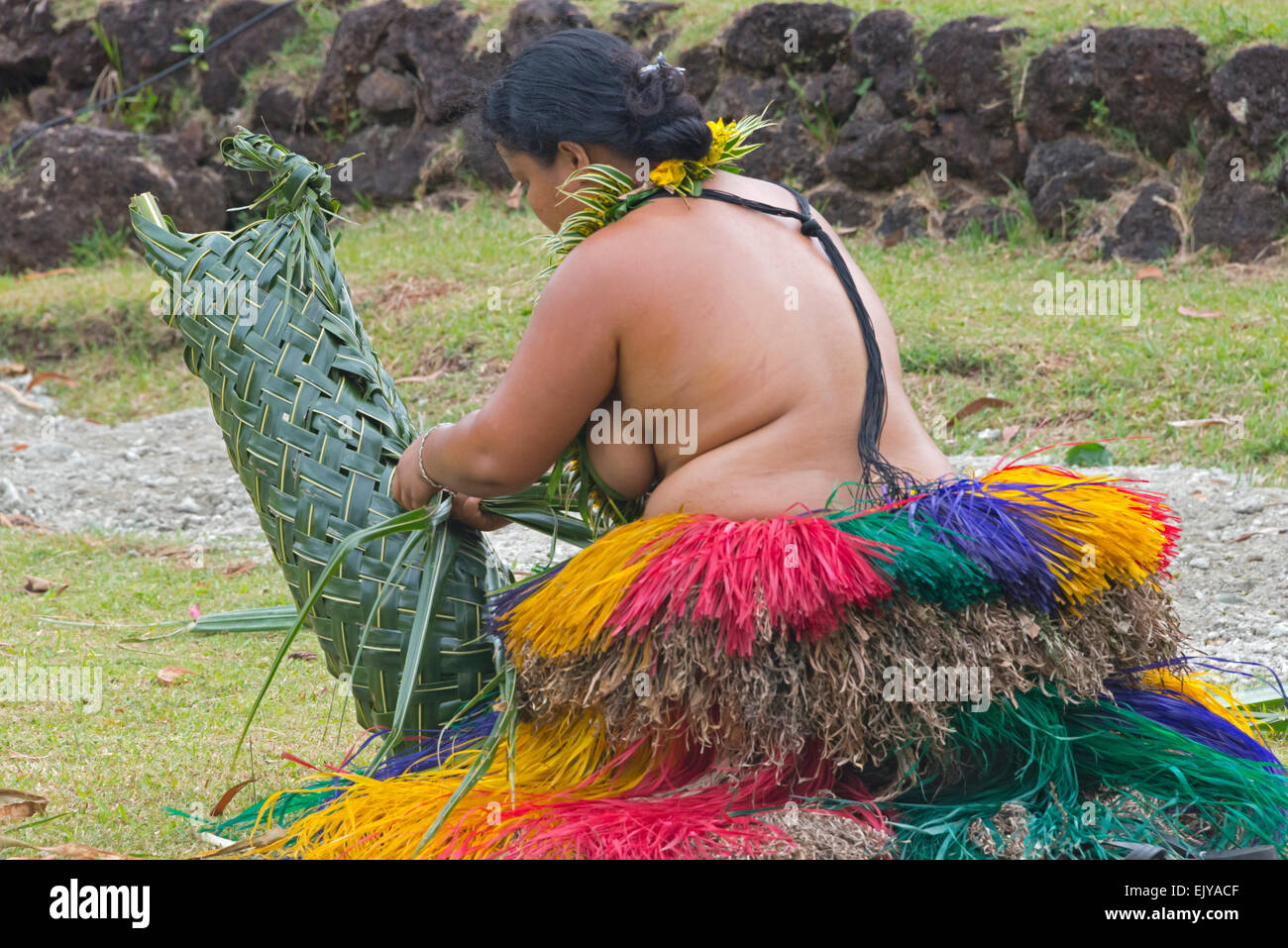 Yapese woman in traditional clothing weaving hand bag with palm tree leaves at Yap Day Festival, Yap Island, Federated States of Stock Photo