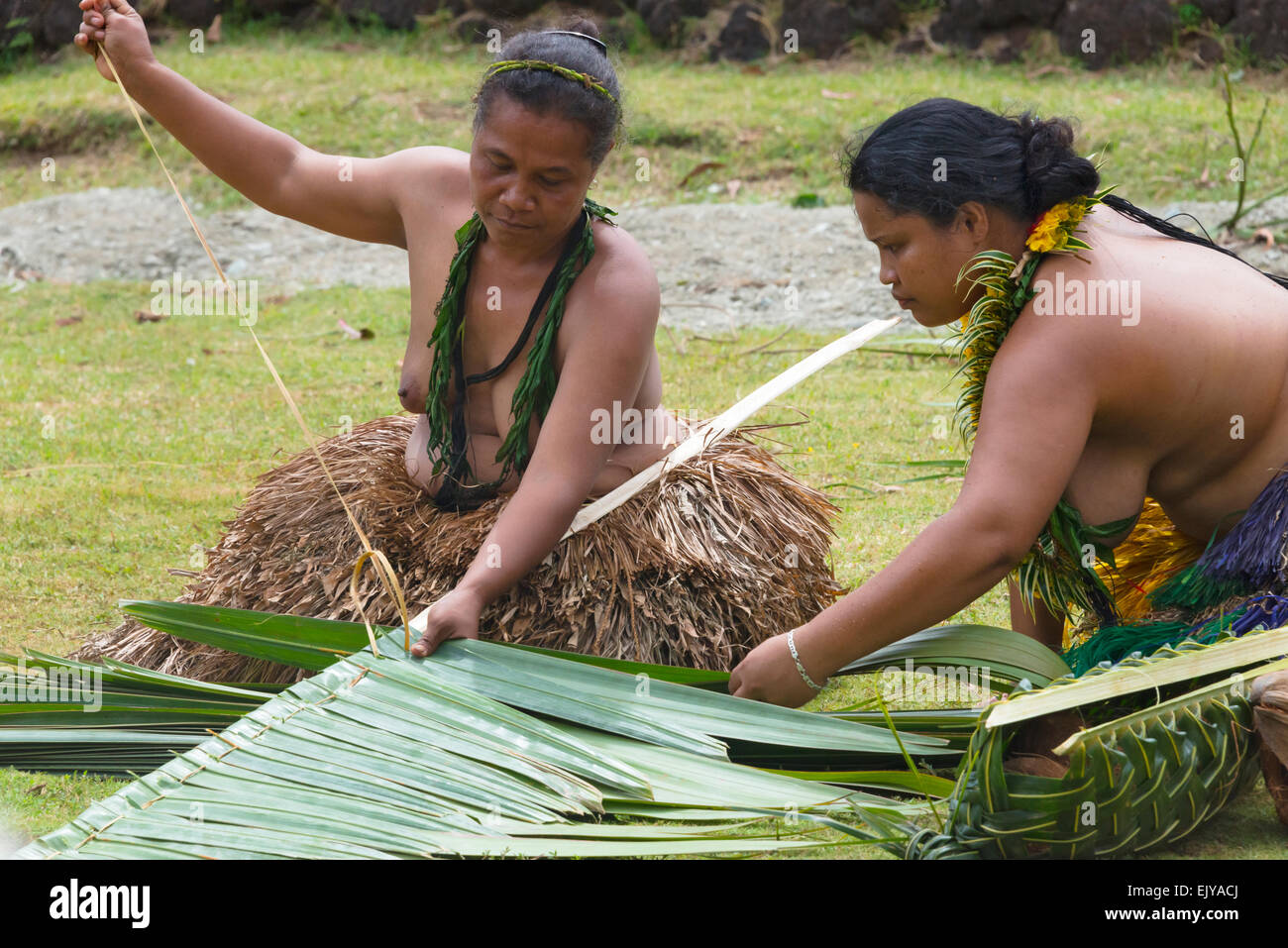 Yapese woman in traditional clothing weaving hand bag with palm tree leaves at Yap Day Festival, Yap Island, Federated States of Stock Photo