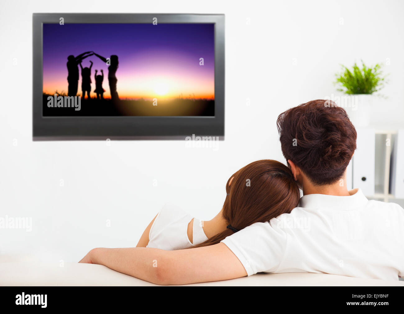 young couple watching the family concept tv show Stock Photo