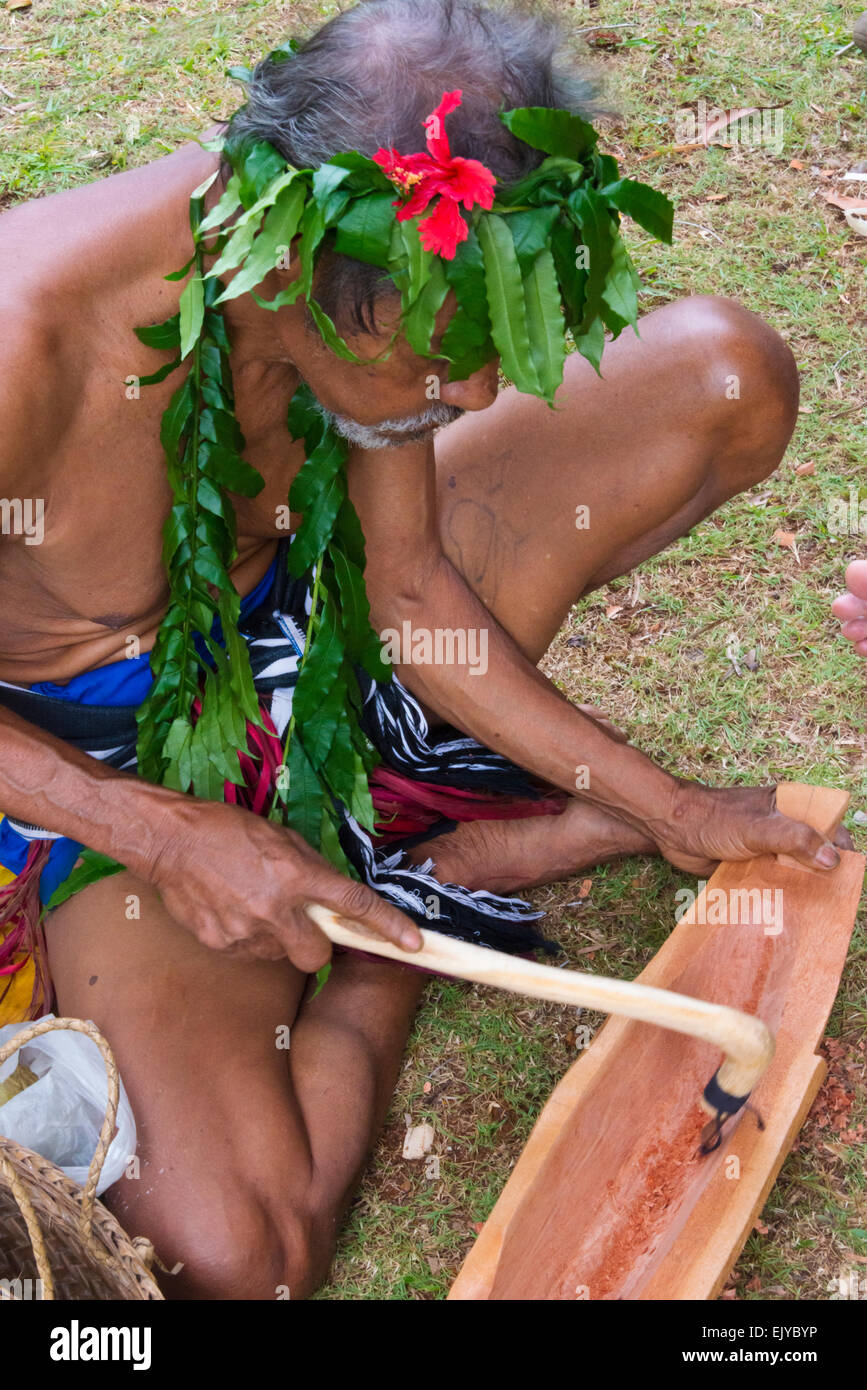 Yapese man in traditional clothing making craft, wood carving, at Yap Day Festival, Yap Island, Federated States of Micronesia Stock Photo