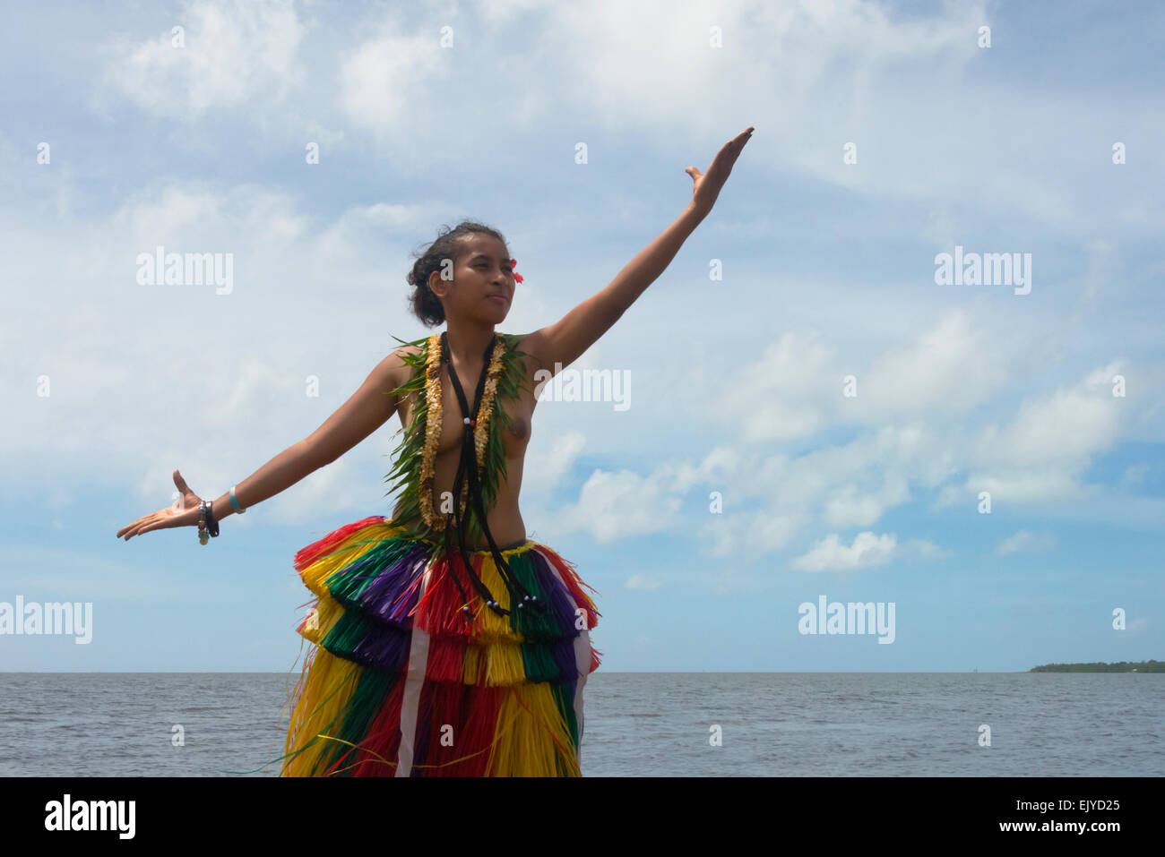 Yapese girl in grass skirt dancing by the ocean, Yap Island, Federated