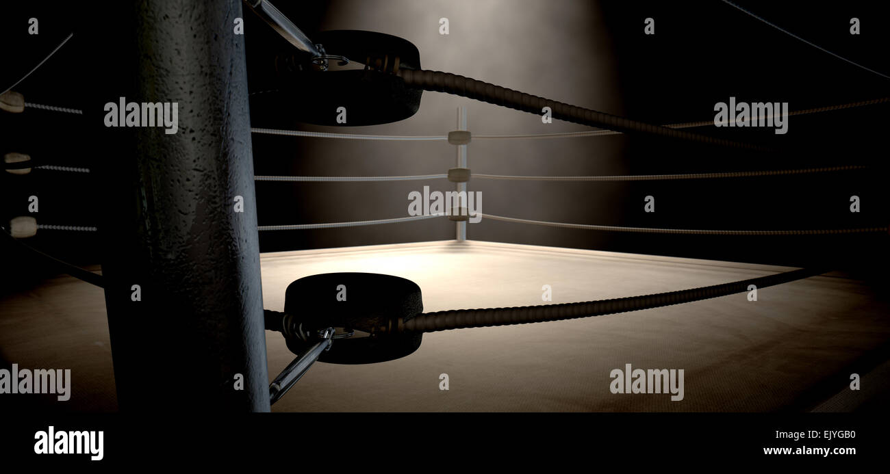 A closeup of the corner of an old vintage boxing ring surrounded by ropes spotlit by a spotlight on an isolated dark background Stock Photo
