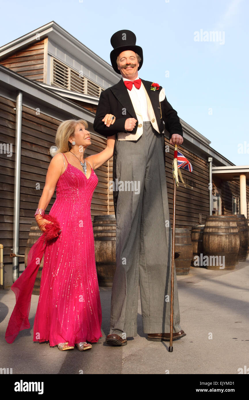 TV celebrity Jennie Bond stands alongside a man on stilts dressed as Brunel at an corporate evening event in Bristol Stock Photo