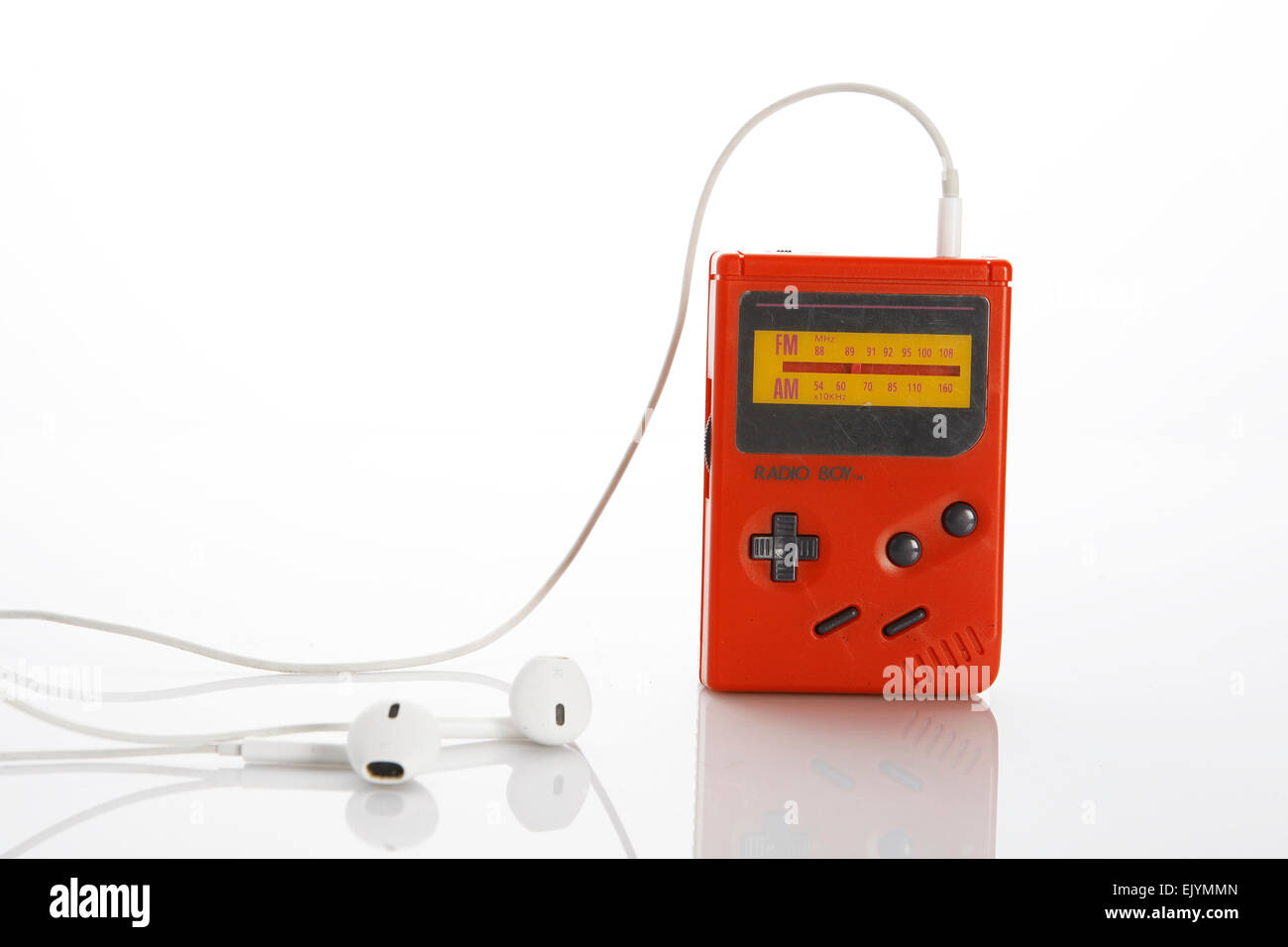 And old, vintage, red gameboy radio with white earphones on white background Stock Photo