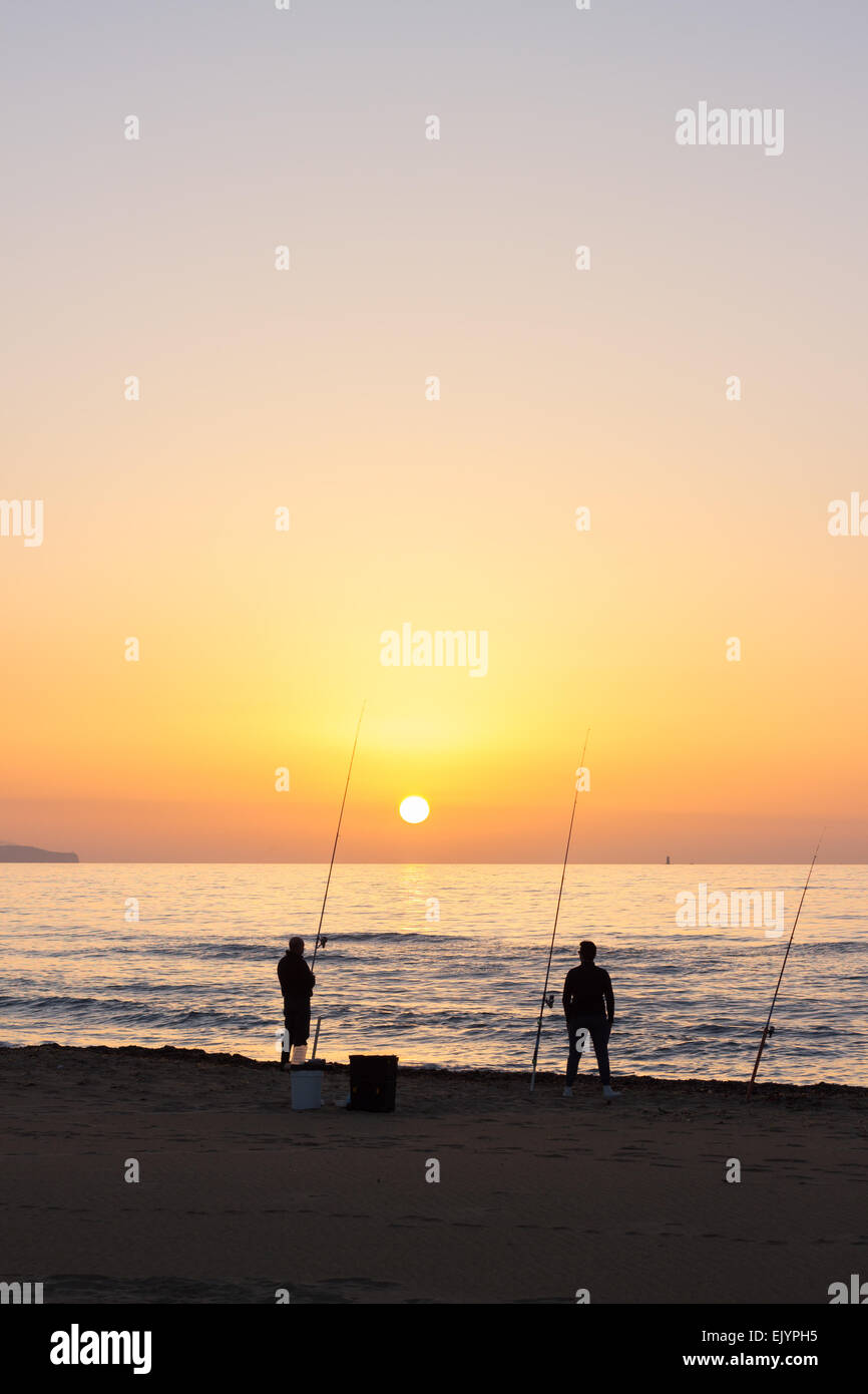 people silhouettes men fishing sunset sea sun beach ocean Stock Photo -  Alamy