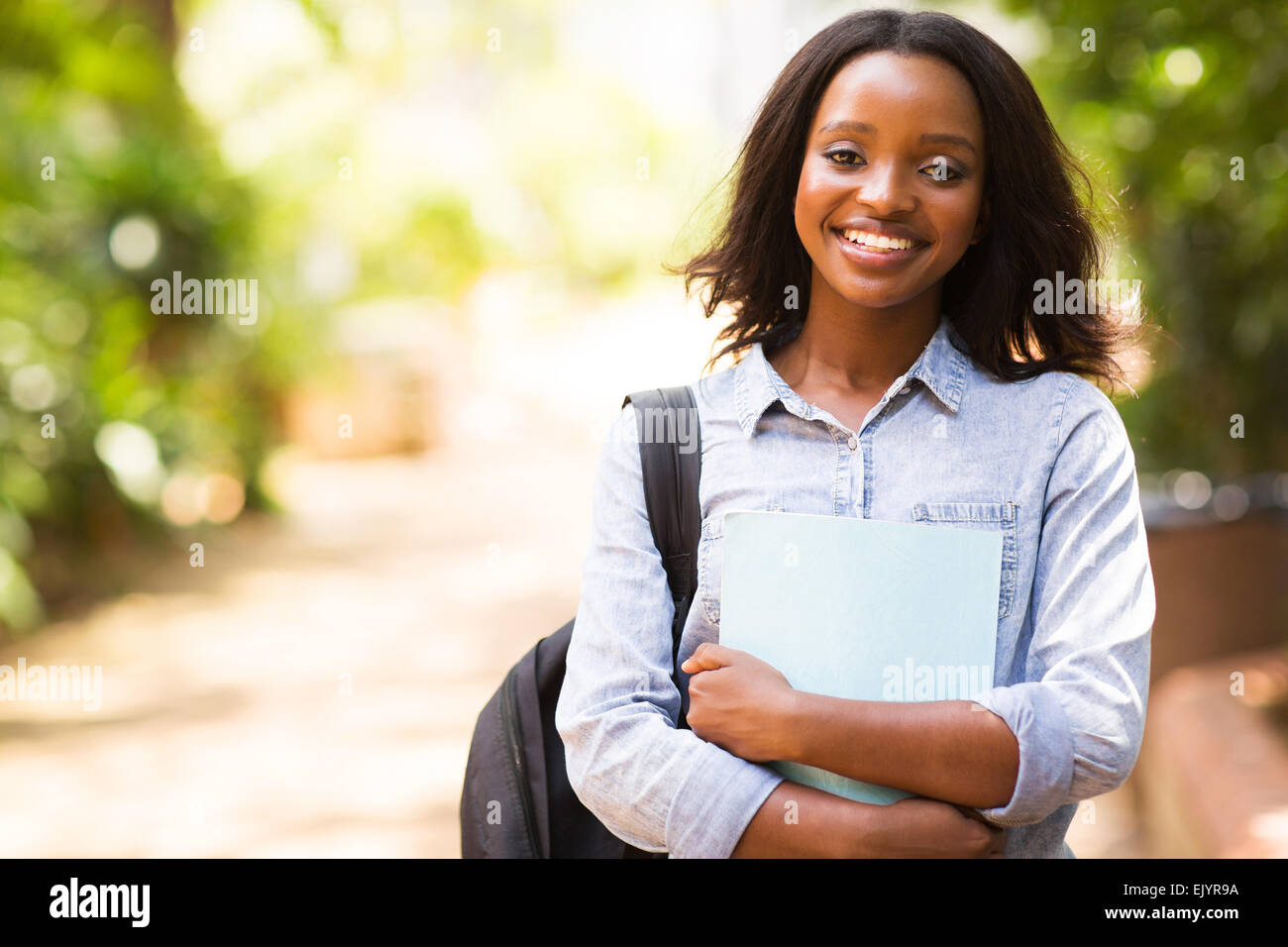 portrait of African college student holding a book Stock Photo - Alamy