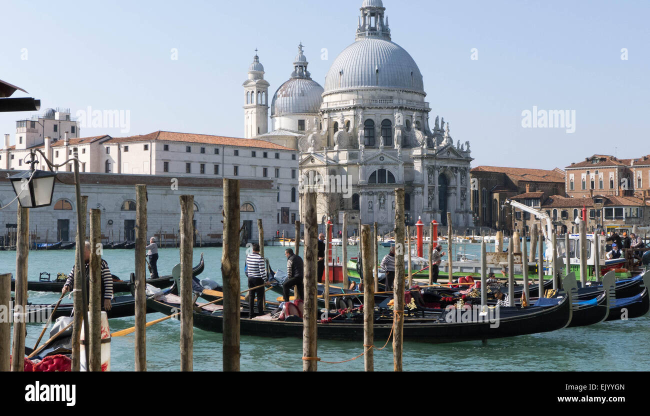 Gondolas moored on the Grand Canal in Venice with the Santa Maria Della Salute church in the background. Stock Photo