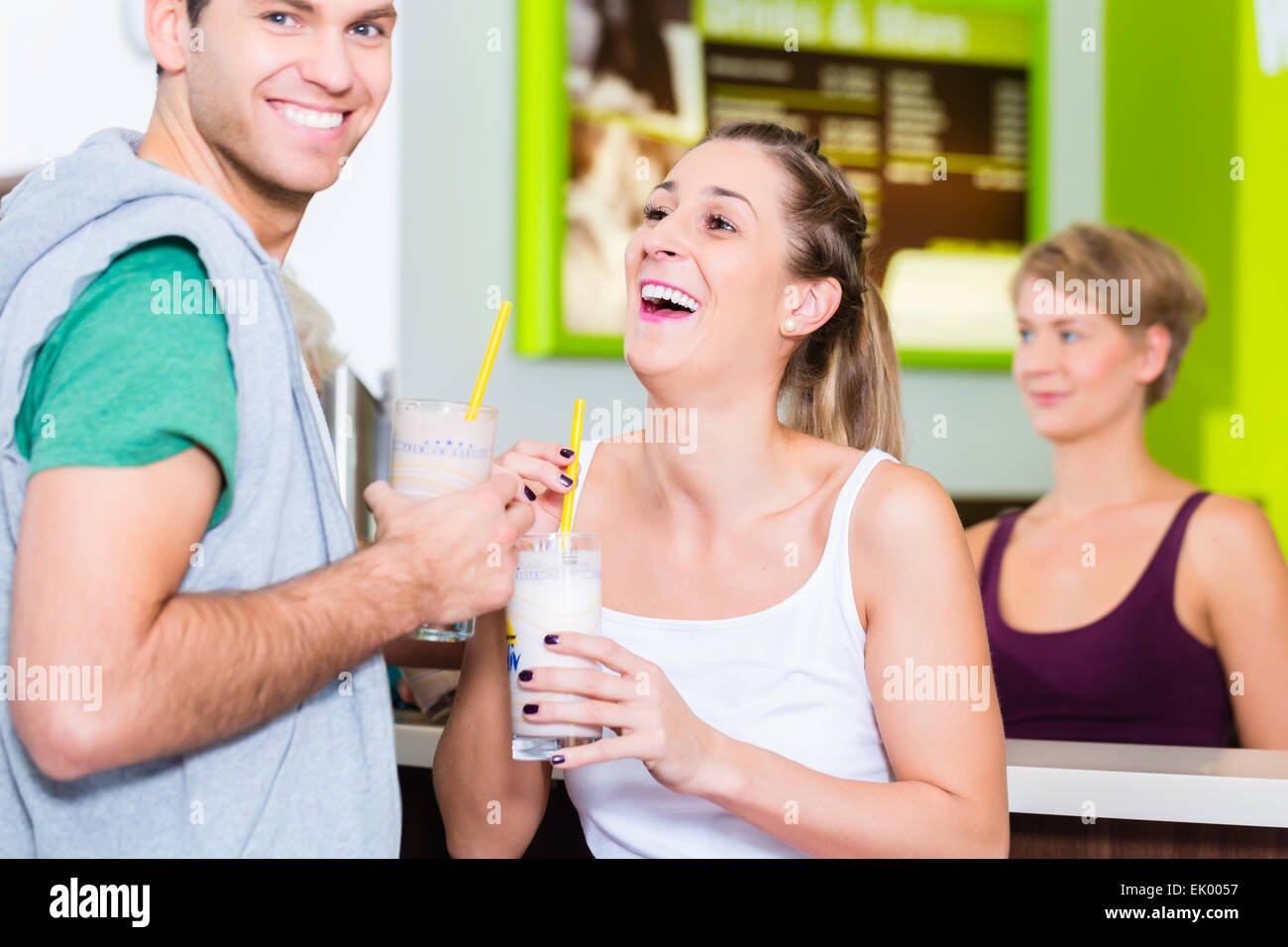 People drinking protein shakes in fitness gym bar Stock Photo