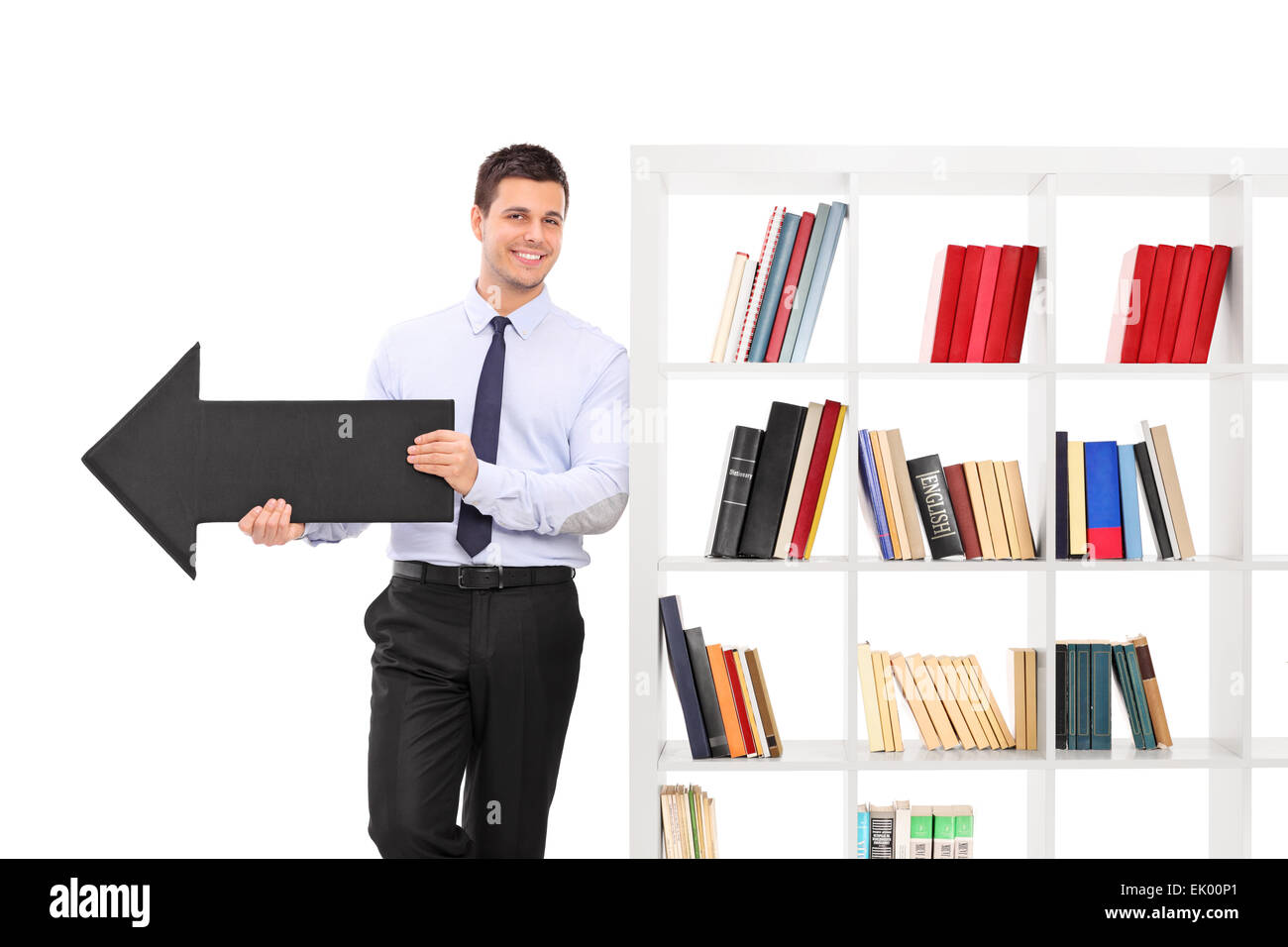 Cheerful young guy holding a big black arrow pointing right and leaning ...