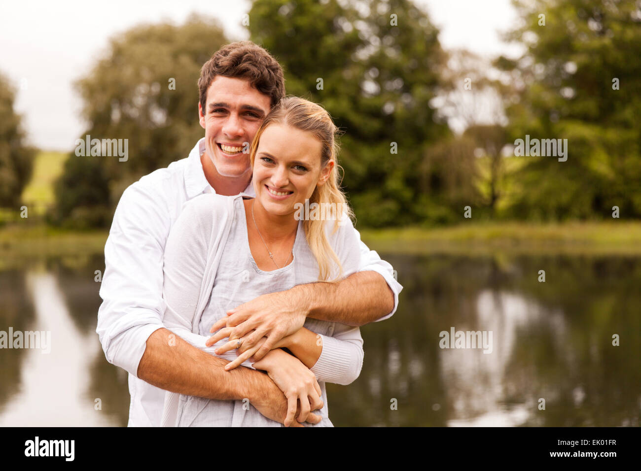 portrait of beautiful young couple hugging by the lake Stock Photo - Alamy