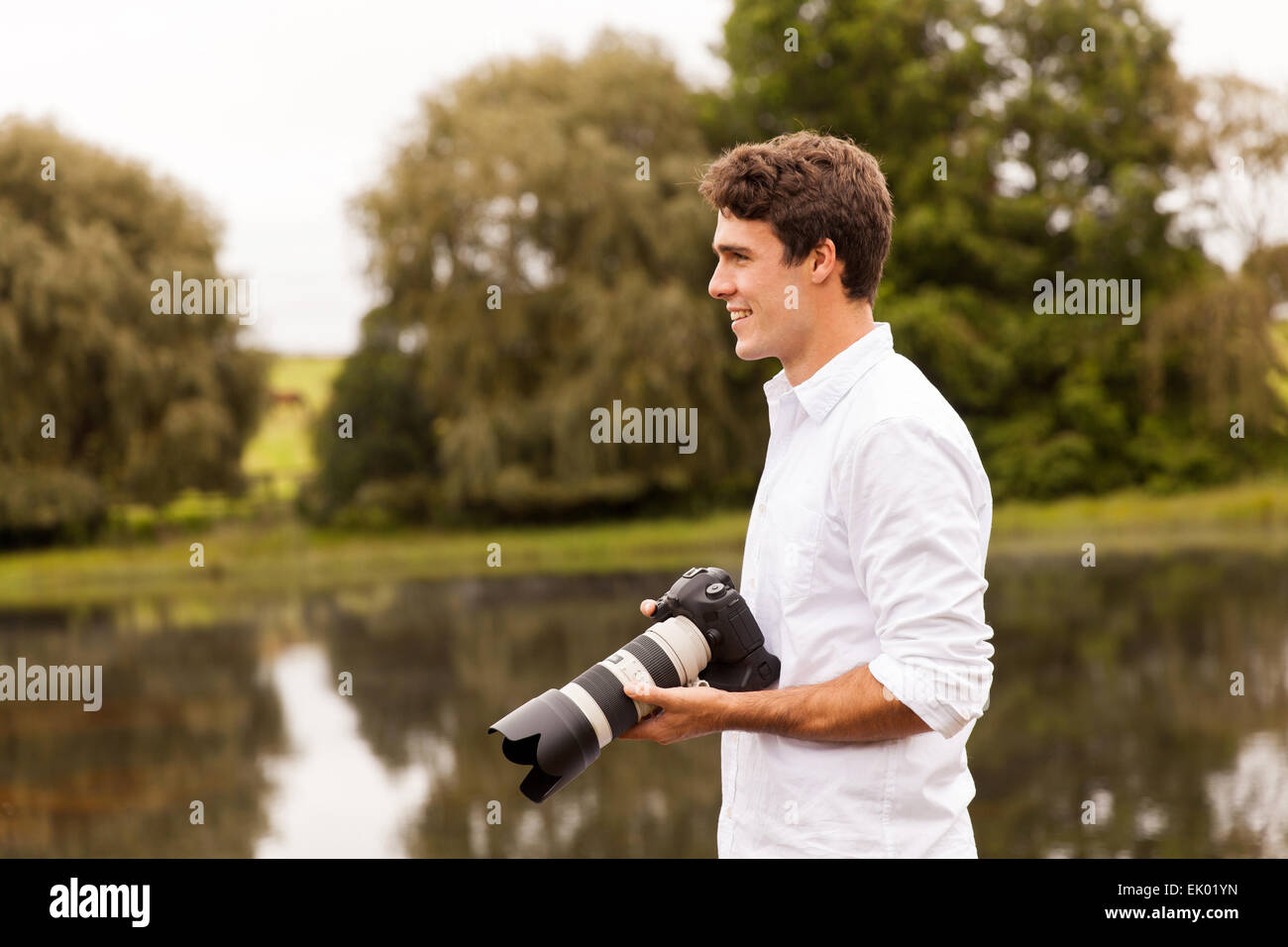 handsome young male photographer with dslr camera outdoors Stock Photo