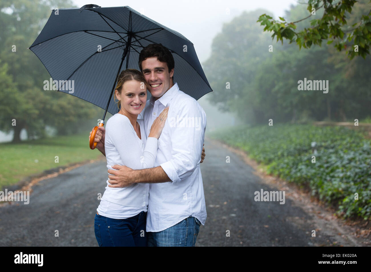 cute young couple under an umbrella in the mist Stock Photo