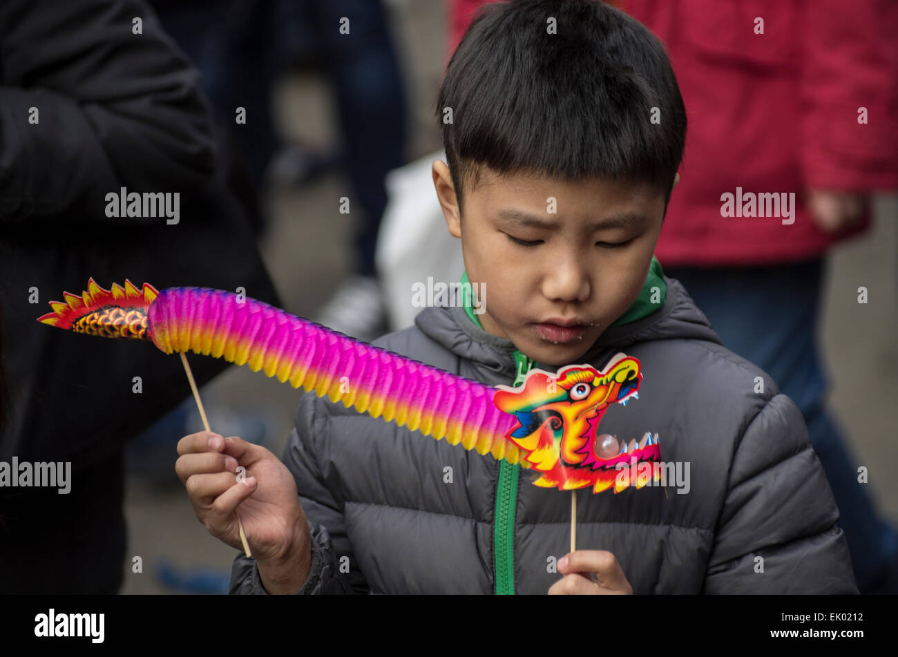 Chinese boy celebrating chinese new years with his colourful paper dragon in Chinatown, London, England Stock Photo