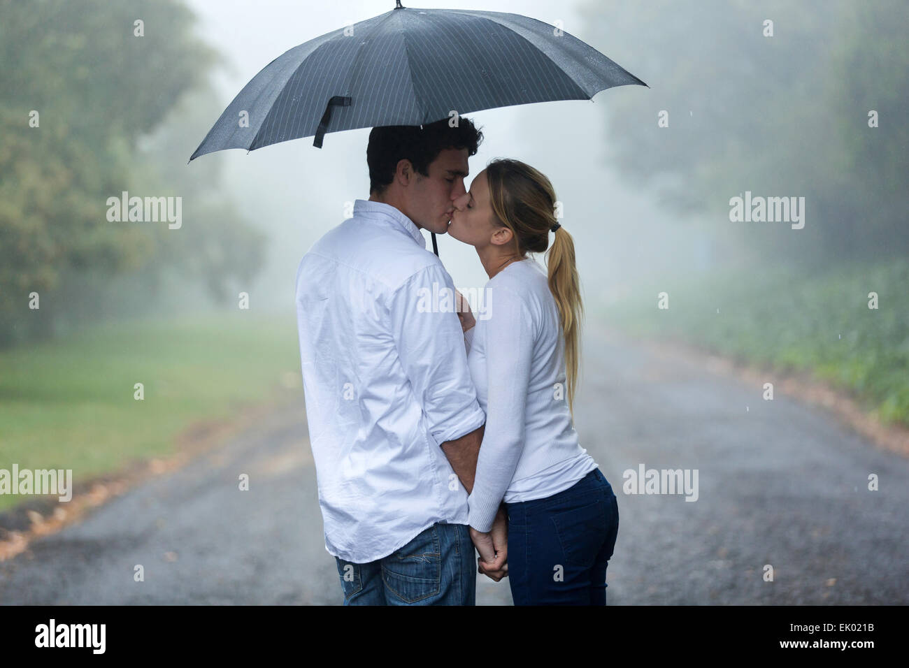 loving young couple in love under umbrella in the rain Stock Photo