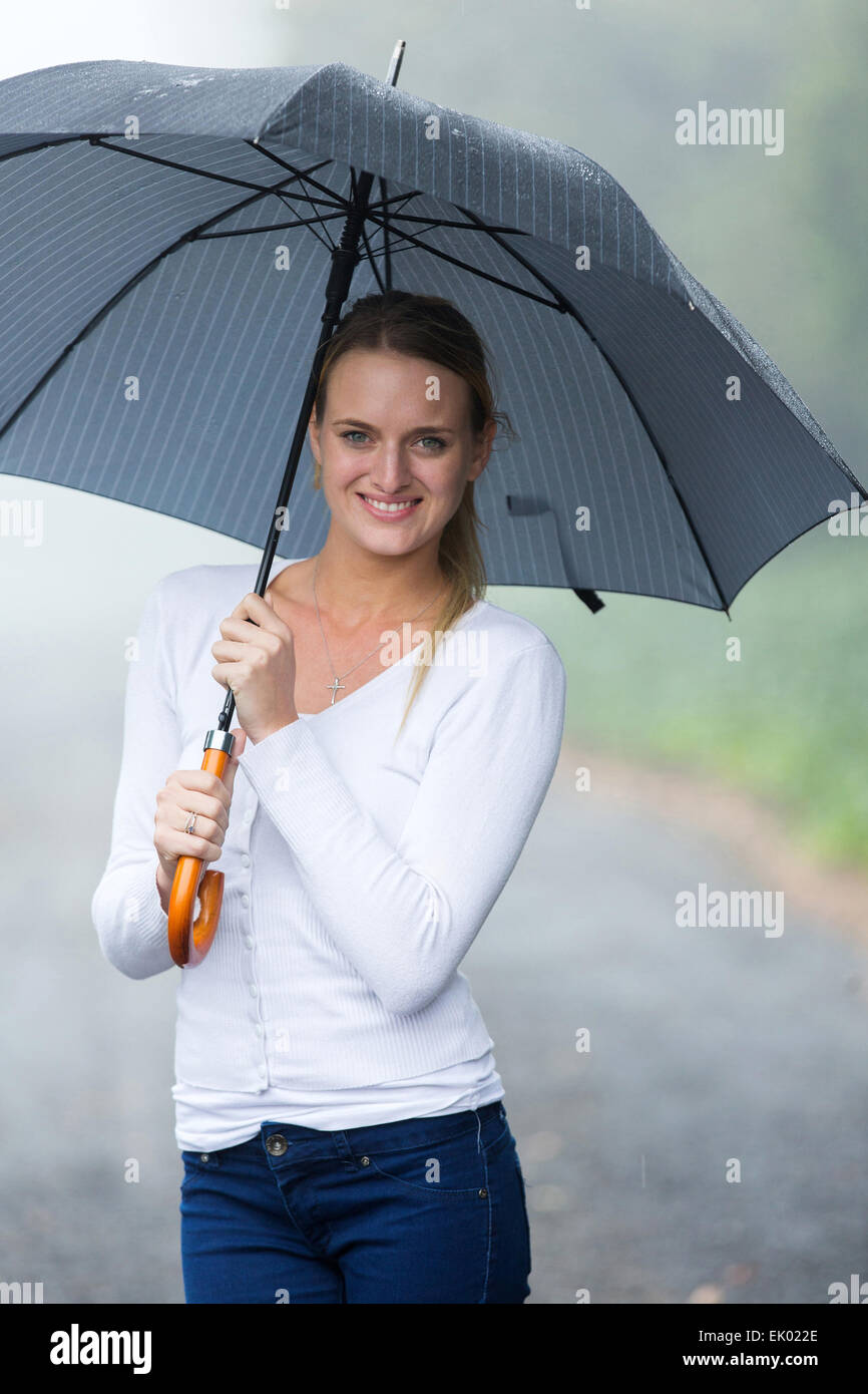 beautiful young woman holding umbrella in the rain Stock Photo