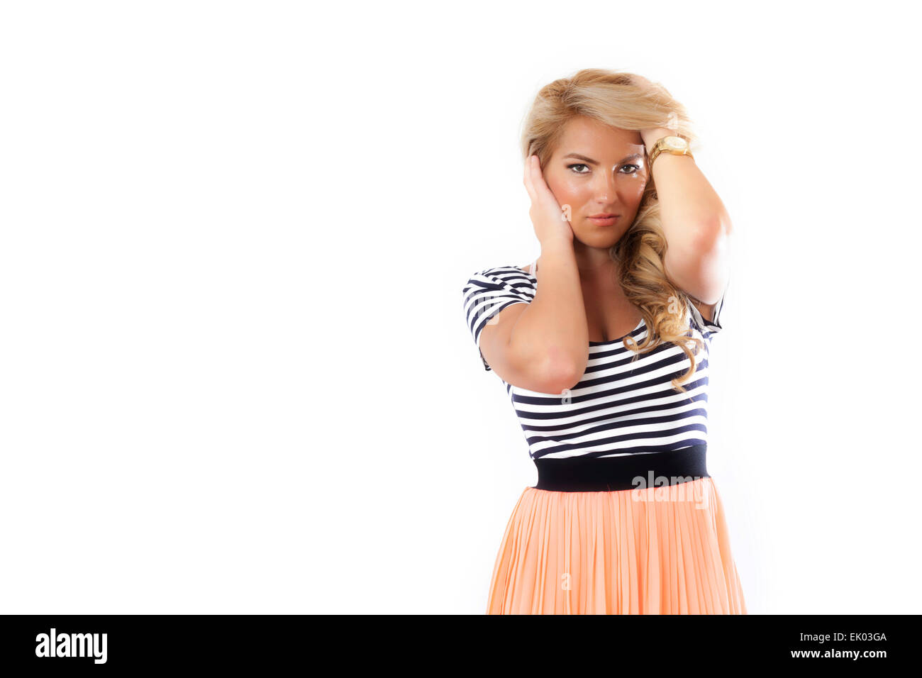 A blonde Latina girl in a black and white top and orange skirt and gold watch. Isolated on white background. Stock Photo