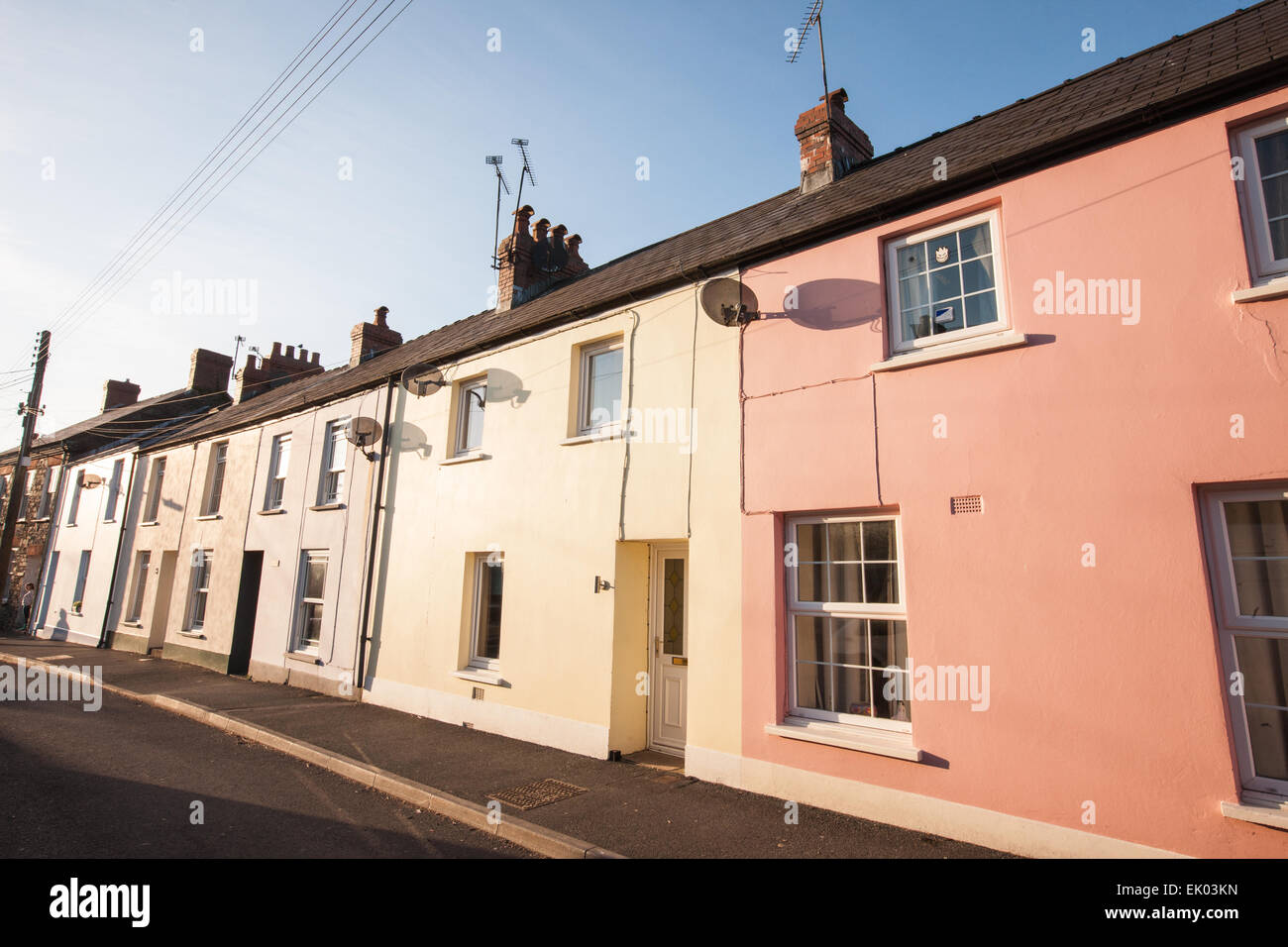 Pastel coloured terrace houses in centre of Laugharne at sundown during