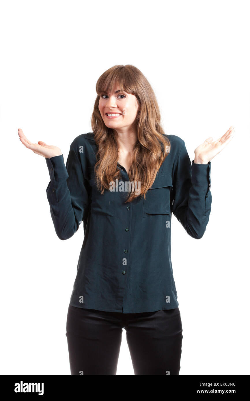 A tall, thin, pretty brunette model in blue shirt and black pants, acting confused with her hands up in the air. Isolated on whi Stock Photo