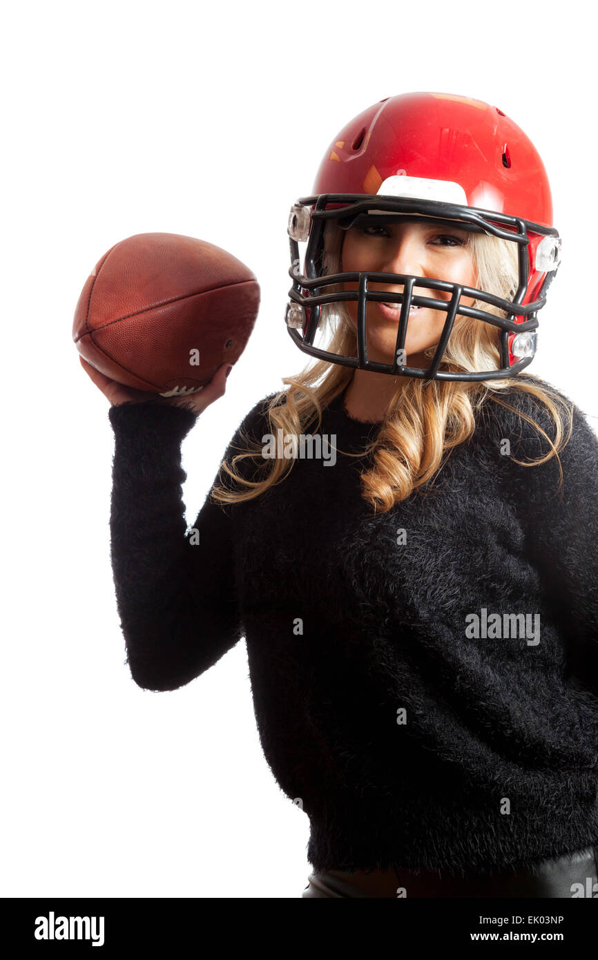 A pretty, Latina, blonde girl wearing a red football helmet and throwing a football. On isolated white background. Stock Photo