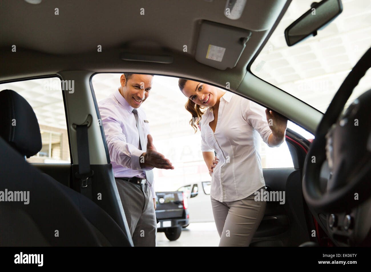 friendly car dealer showing new car to customer Stock Photo
