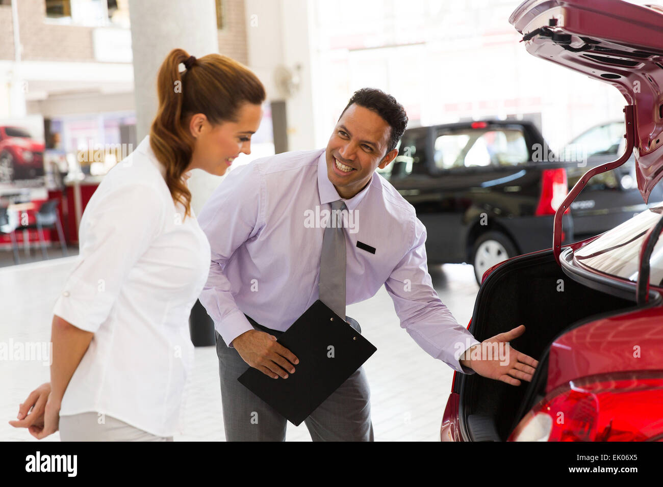 handsome car salesman showing new vehicle to customer Stock Photo Alamy