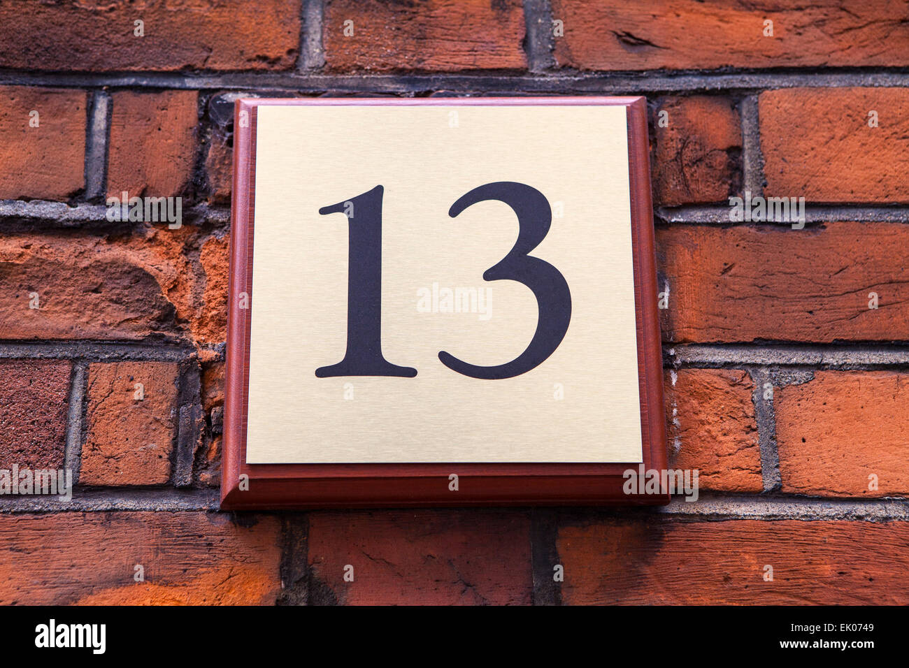 A plaque on a wall displaying the Number 13. Stock Photo