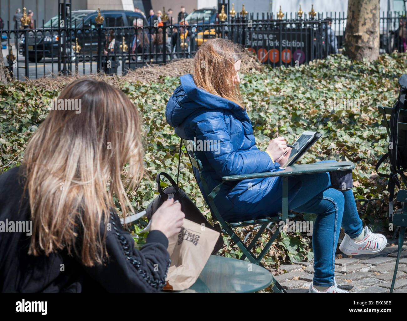 A woman uses her iPad joining other park goers the shedding the winter blues in Bryant Park in New York on Thursday, April 2, 2015. Warm weather in the mid 60's attracted office workers and tourists to the outdoors. (© Richard B. Levine) Stock Photo